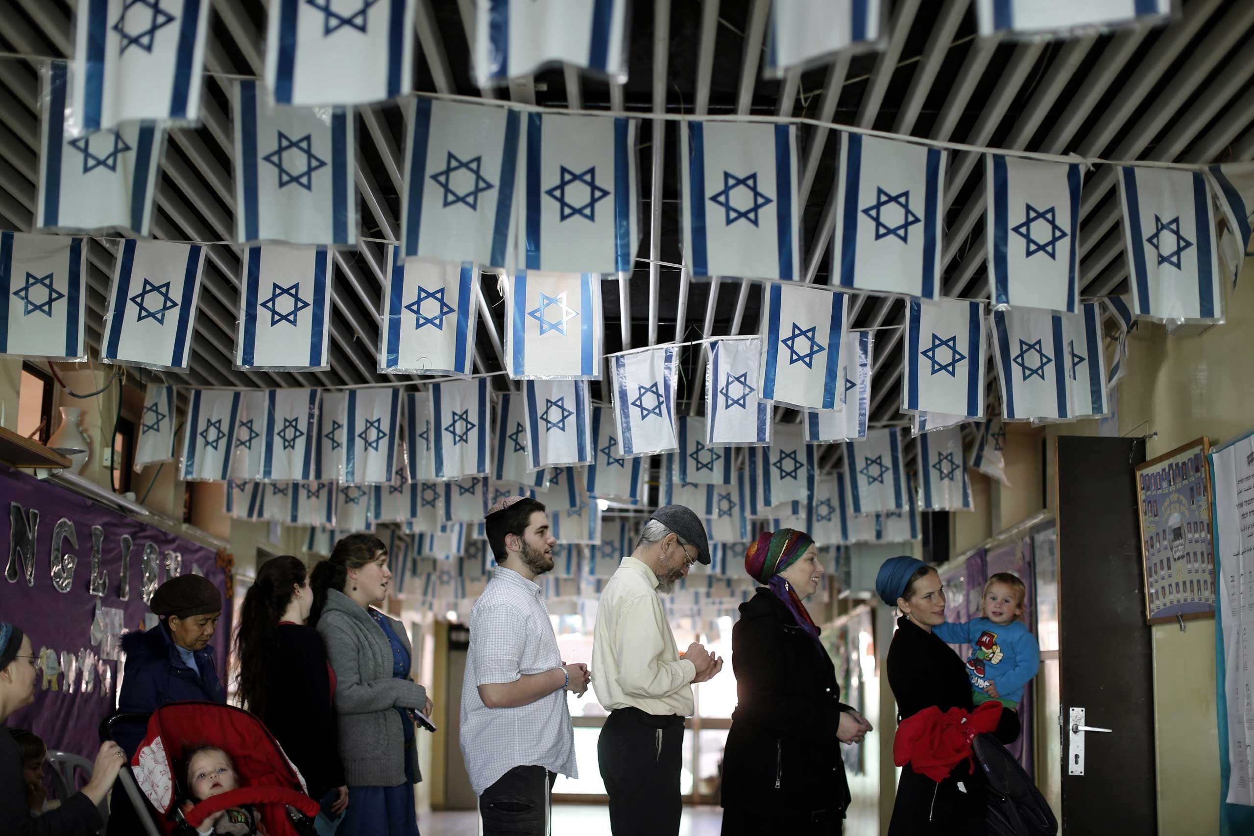 Voters wait in line to vote at a polling station for the Israeli general elections in the West Bank Jewish settlement of Kiryat Arba, near Hebron,March 17, 2015.