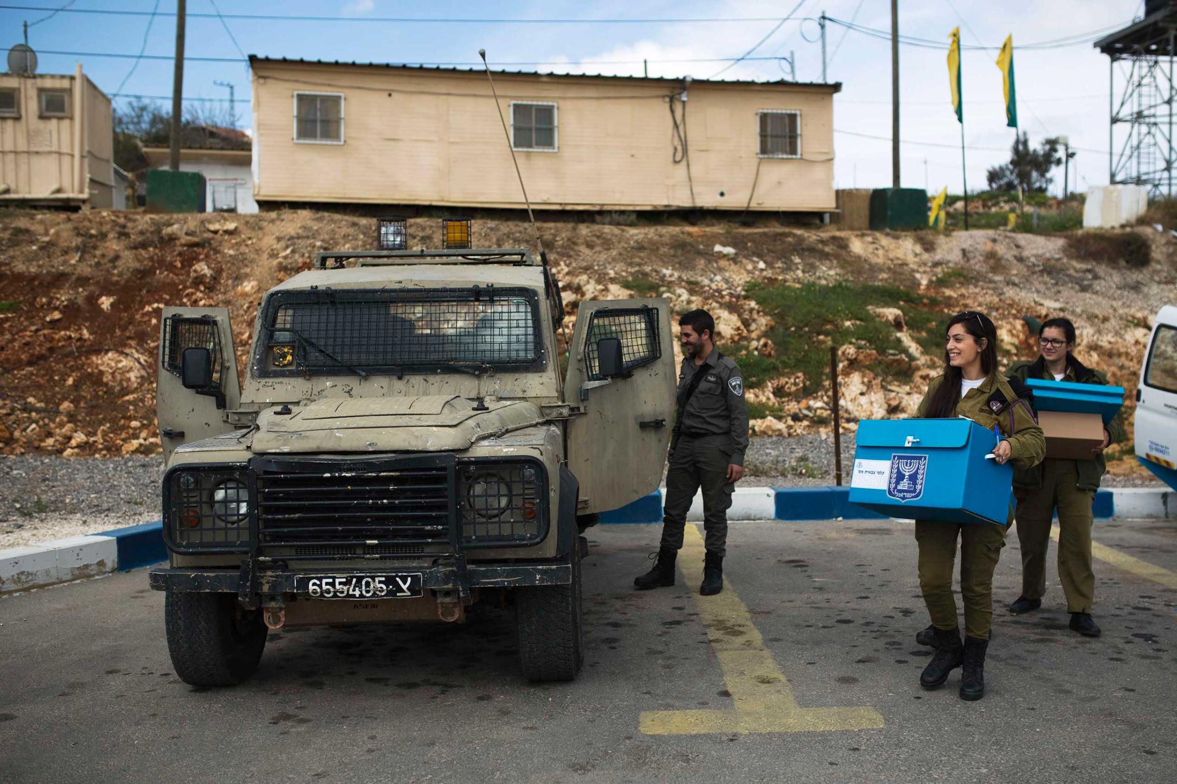 An Israeli soldier carries a mobile ballot box at a border police base in the West Bank near Nablus March 17, 2015.