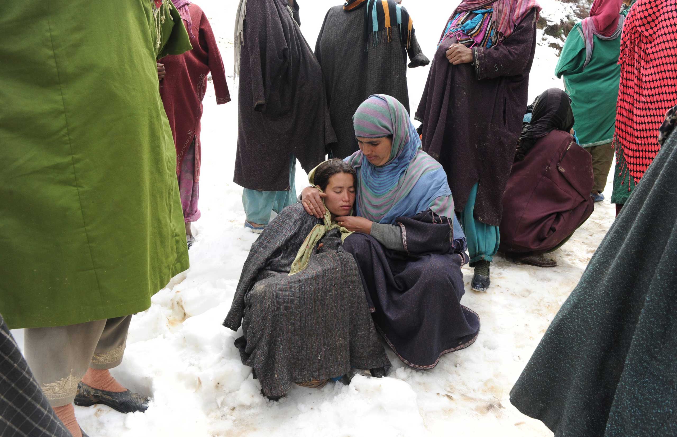 Kashmiri villagers gather during rescue efforts following a landslide due to heavy rainfall in the village of Laden near Chadoora, west of Srinagar, on March 30, 2015.