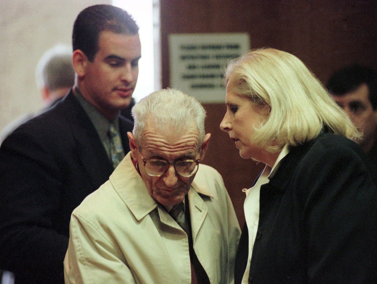 Dr. Jack Kevorkian talks with jury consultant Ruth Holmes (R) as Brad Feldman, one of his legal advisors, listens after Kevorkian's  arraignment in Oakland County Circuit Court, Dec. 16, 1998 (Jeff Kowalsky—AFP/Getty Images)