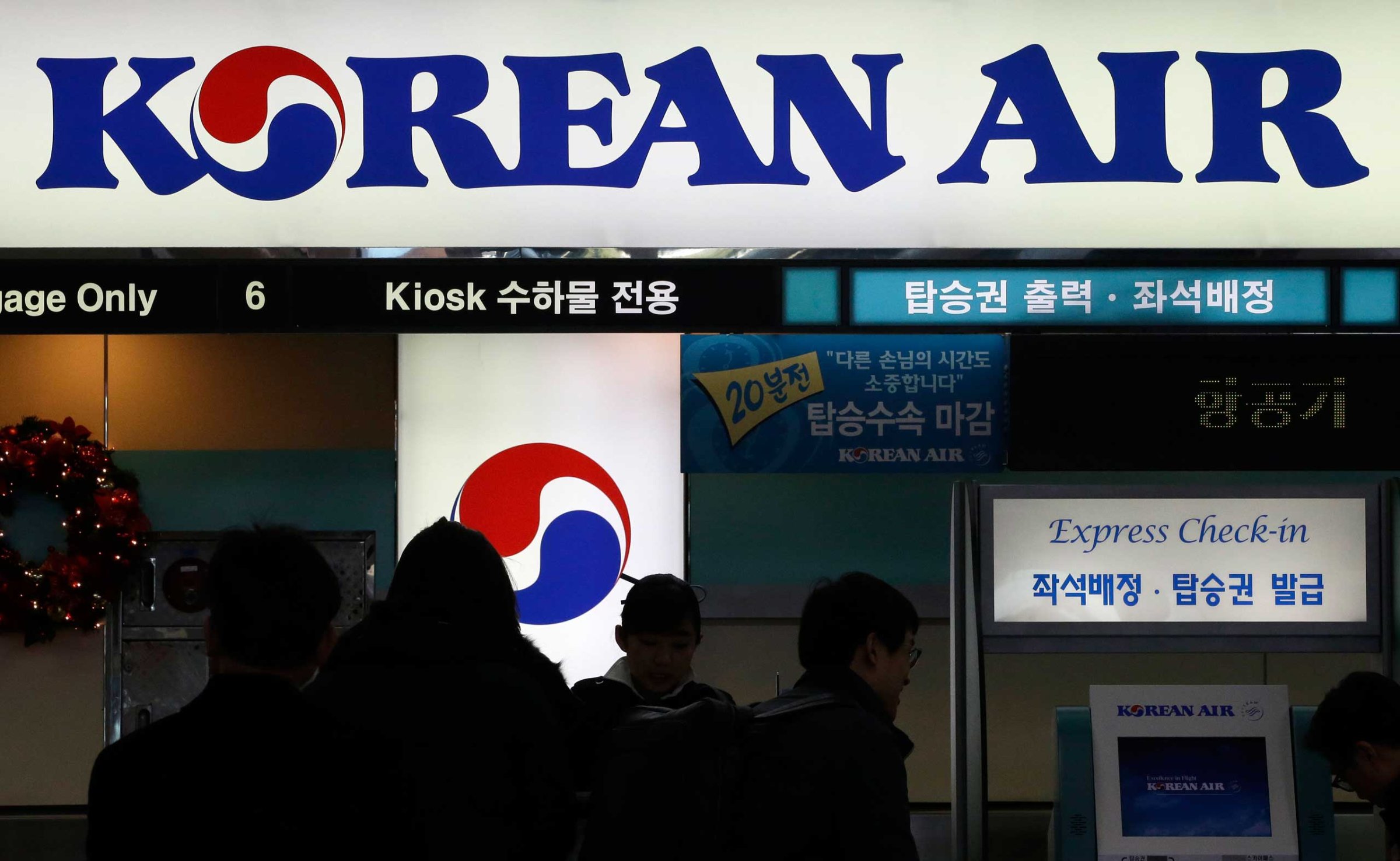 Passengers wait to check in at the domestic check-in desk of Korean Air Lines Co. at Gimpo Airport in Seoul, South Korea, Dec. 2014.