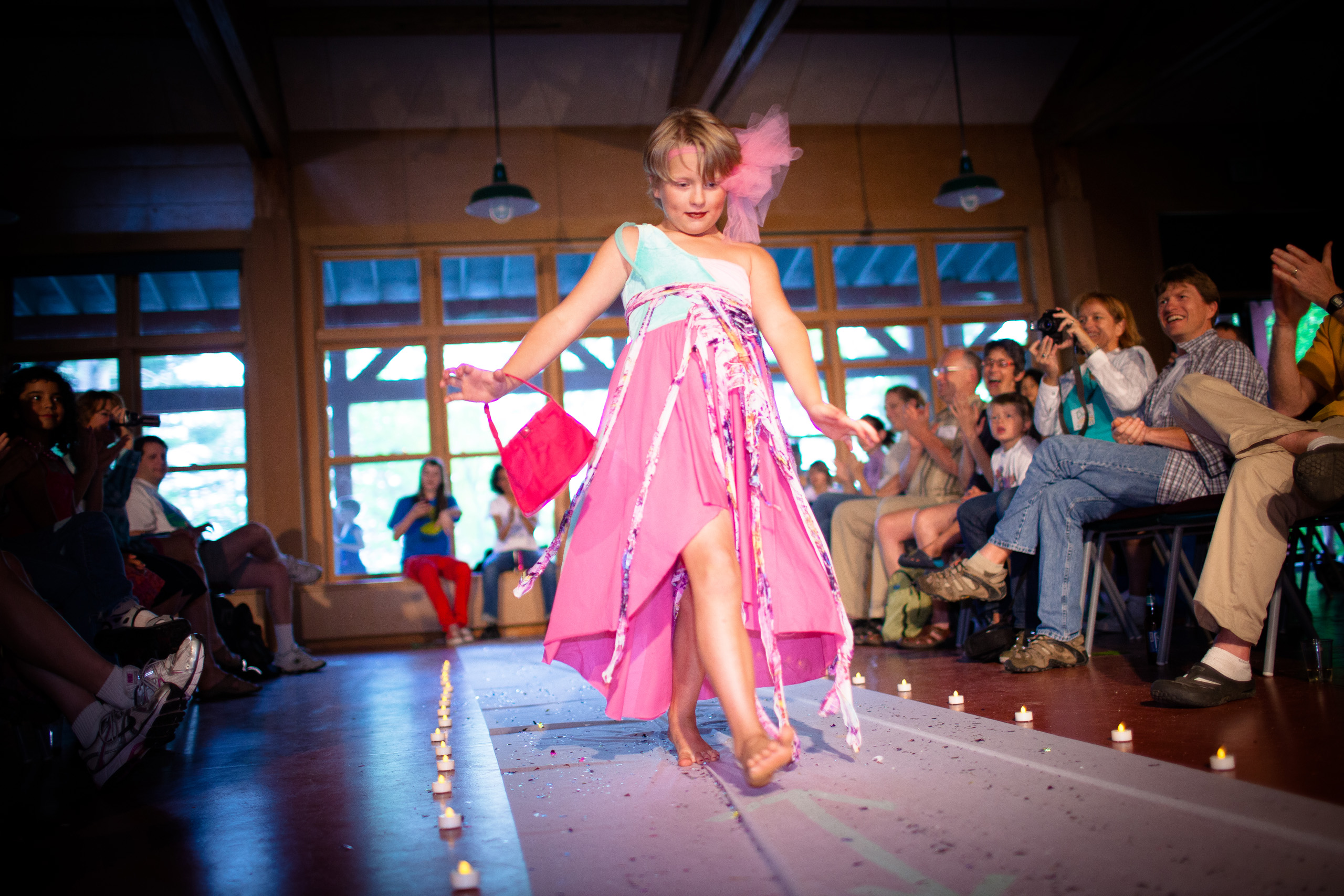 A camper walks down the runway with the enthusiastic support from the camp community.