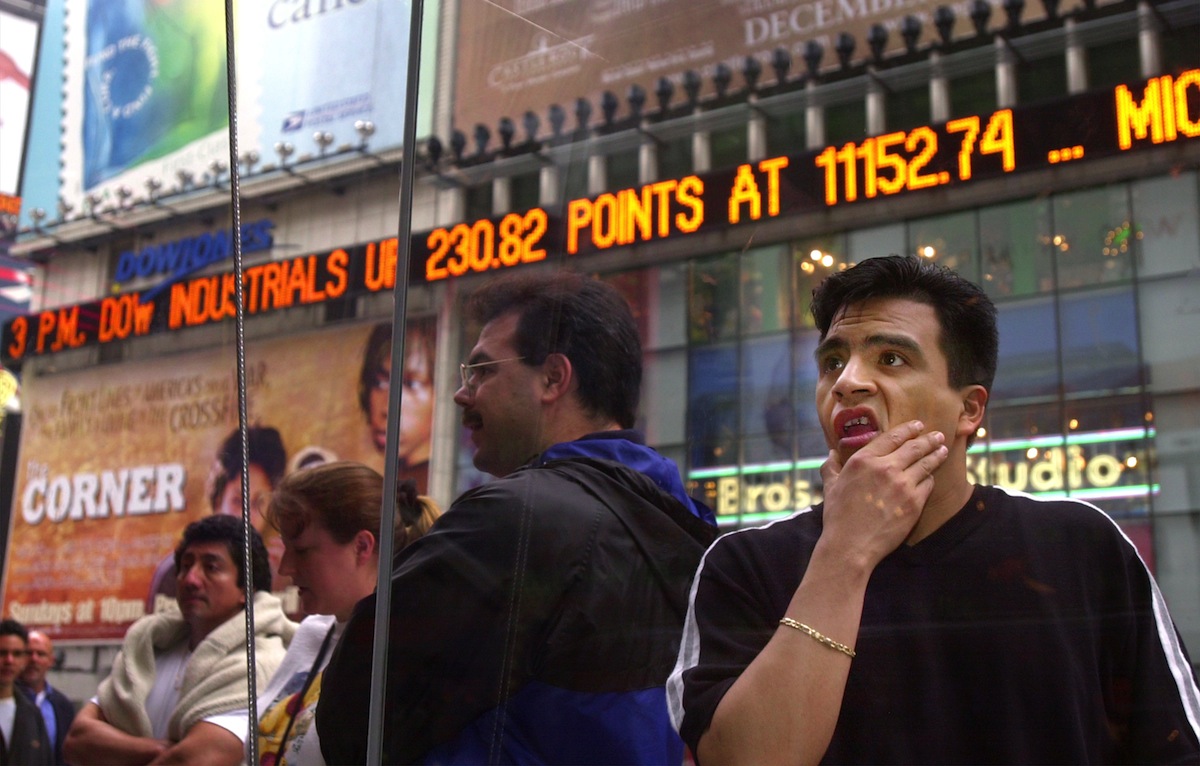 A passer-by looks over the prices on the Nasdaq board in Times Square in New York, April 3, 2000. (Chris Hondros—Getty Images)