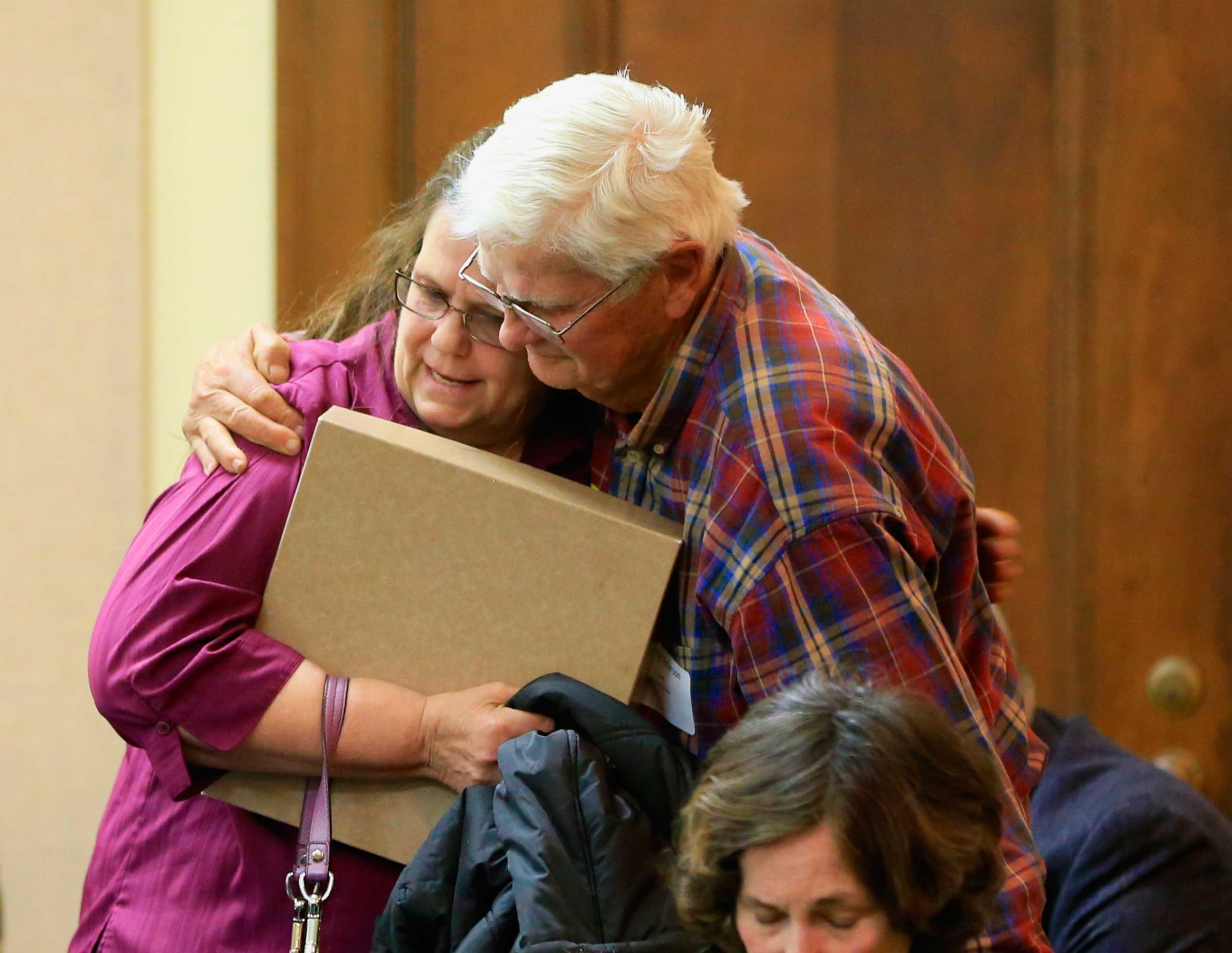 Miriam Thimm Kelle, left, whose brother James Thimm was tortured and killed on a southeast Nebraska farm in 1985, is hugged by Byron Peterson of Scottsbluff, after she testified in favor of a law proposal to change the death penalty to life imprisonment without parole, during a hearing before the Judiciary Committee in Lincoln, Neb., March 4, 2015.