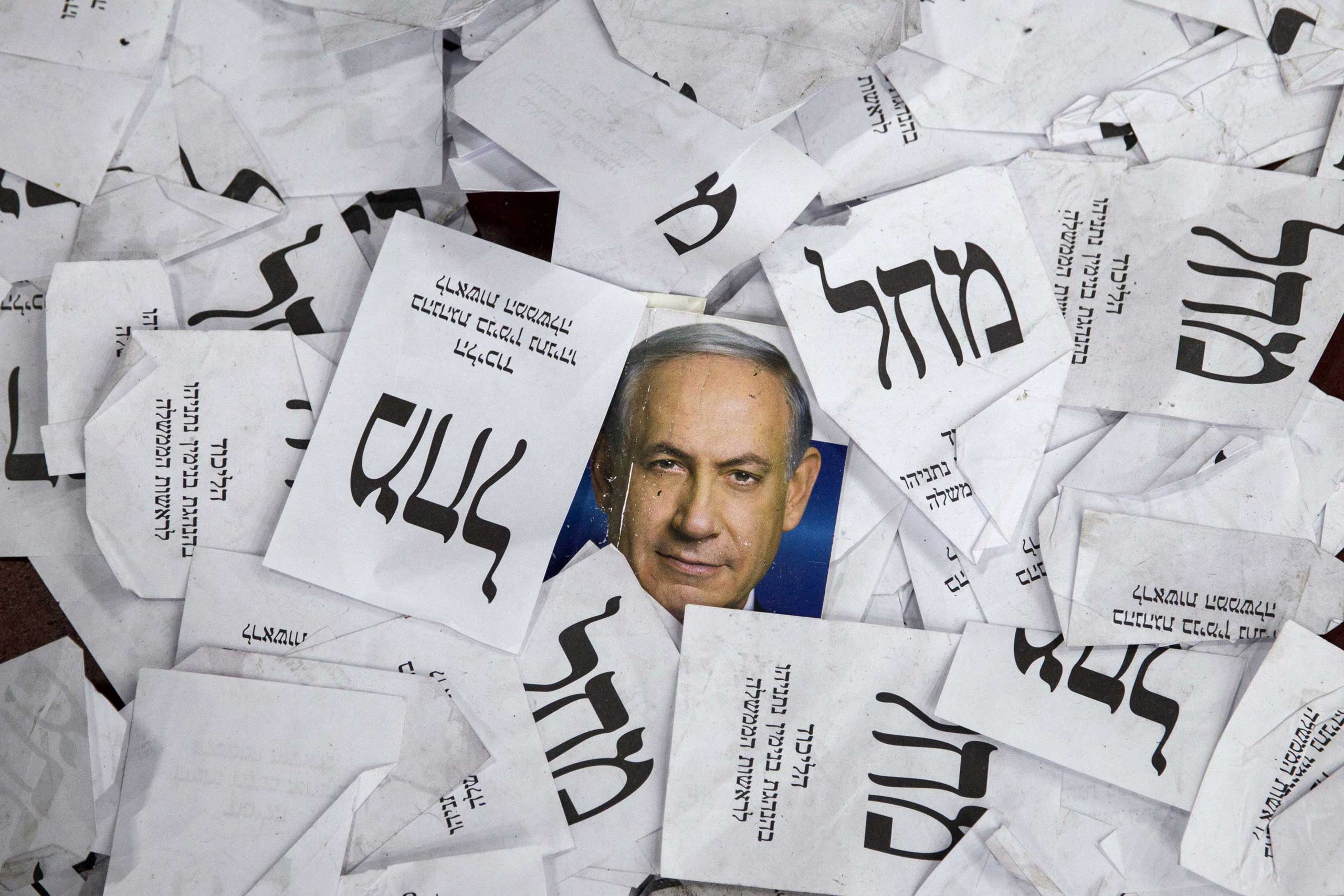 Copies of ballots papers and campaign posters for Israel's Prime Minister Benjamin Netanyahu's Likud Party lie on the ground in the aftermath of the country's parliamentary elections in Tel Aviv on March 18, 2015.