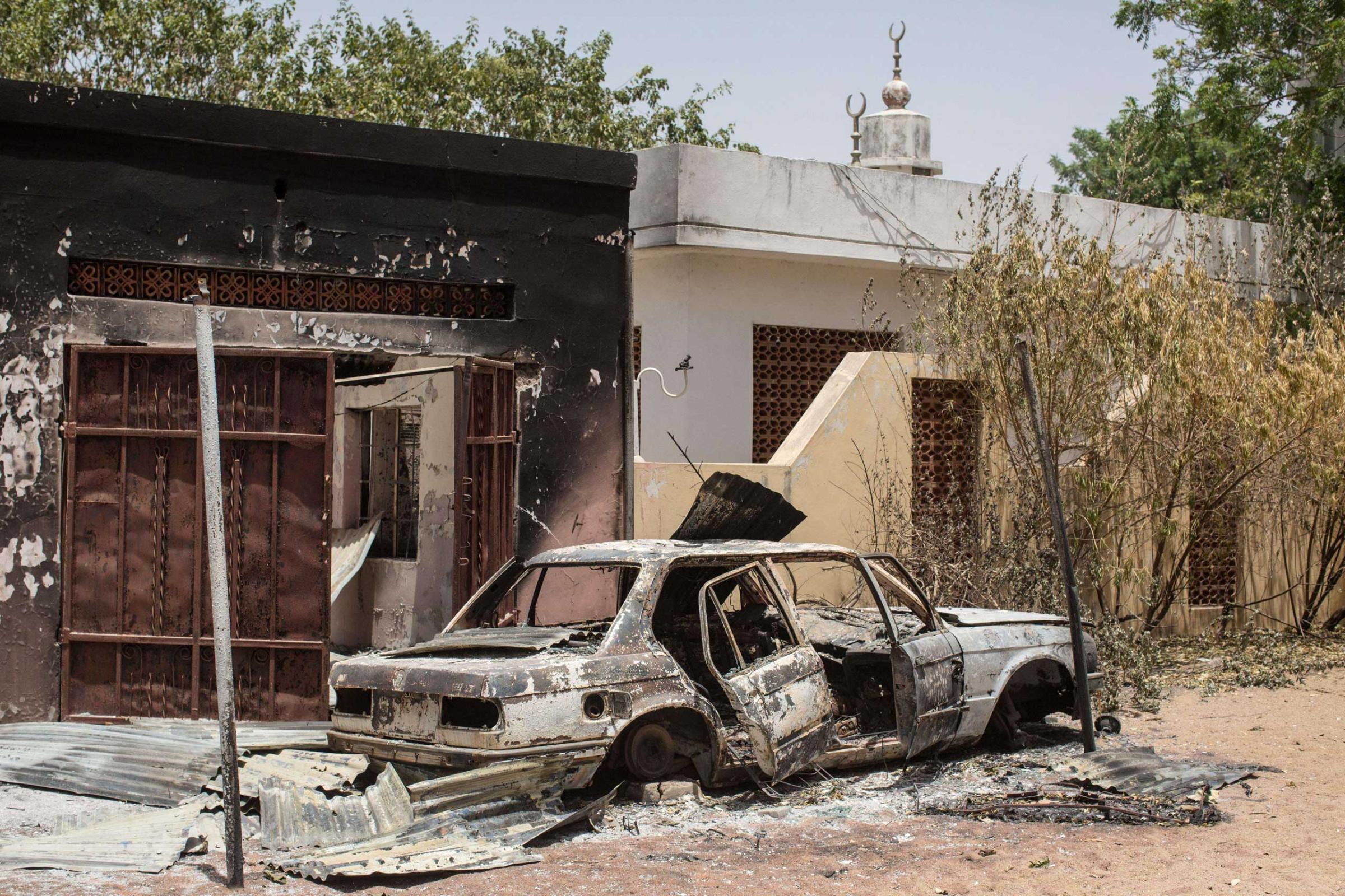 The wreckage of a burnt car outside the former emir's palace that was used by Boko Haram as their headquarters but was burnt down when they fled Bama on taken on March 25, 2015.