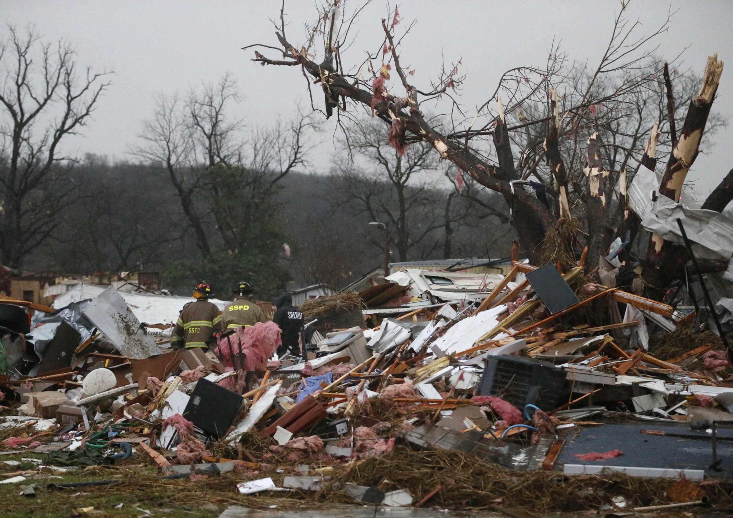 First responders work to free a man from a rubble pile after a round of severe weather hit a trailer park in Sand Springs, Okla., on March 25, 2015.