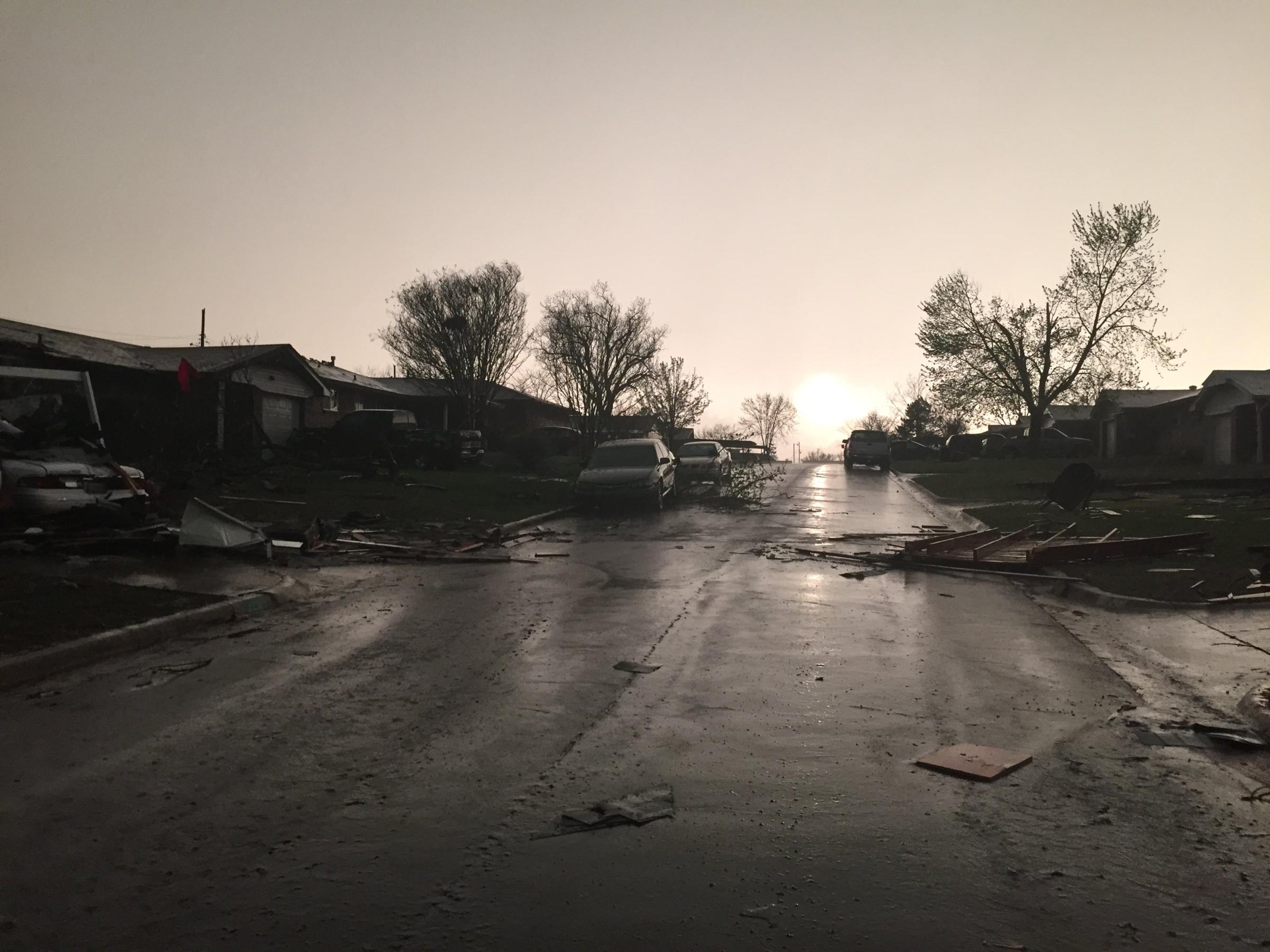 Debris and downed trees litter the streets after a tornado ripped through Moore, Okla. on March 25, 2015.