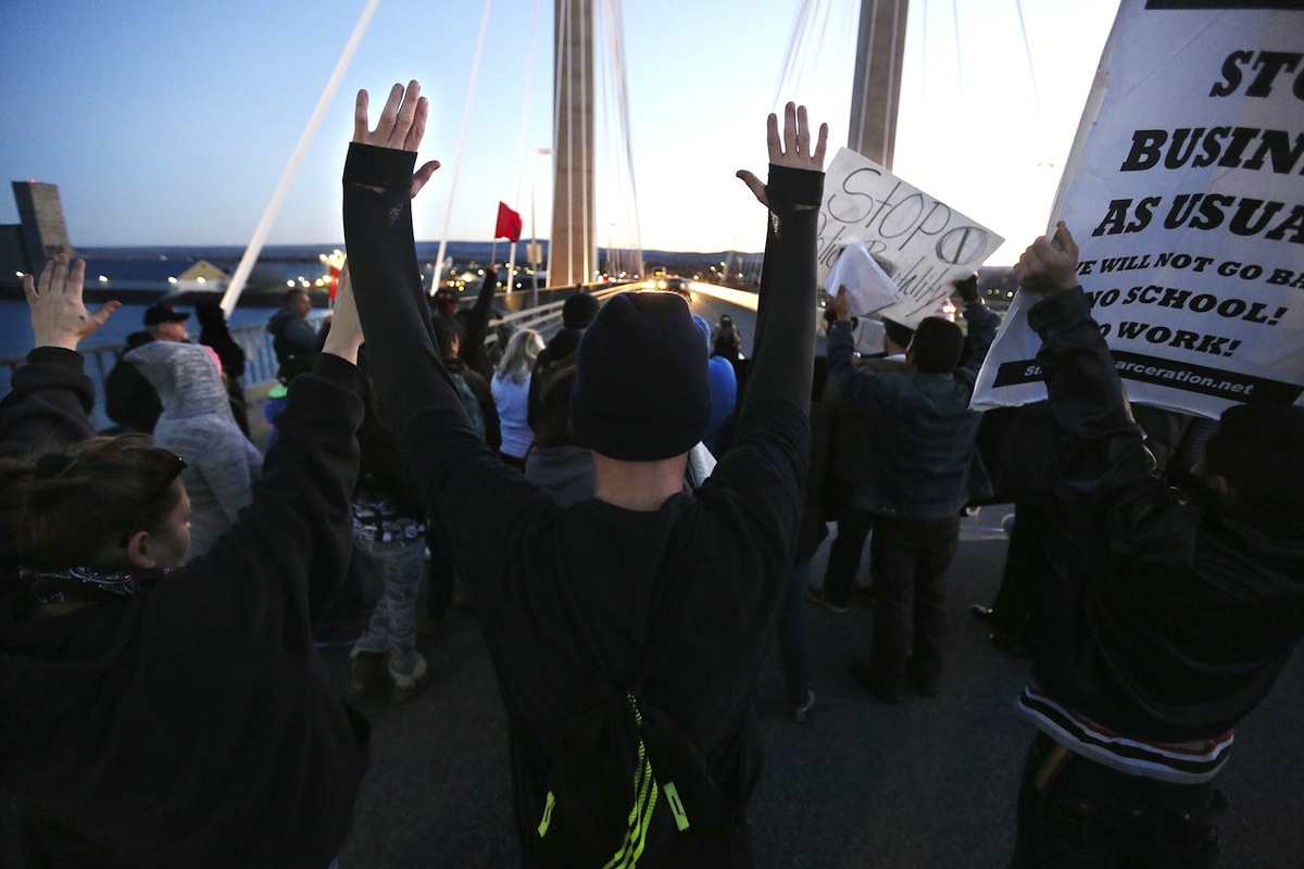 Protesters hold up their hands and signs on Feb. 21, 2015, during a protest stemming from the officer involved shooting death of Antonio Zambrano-Montes (The Tri-City Herald, Andrew Jansen—AP Photo)