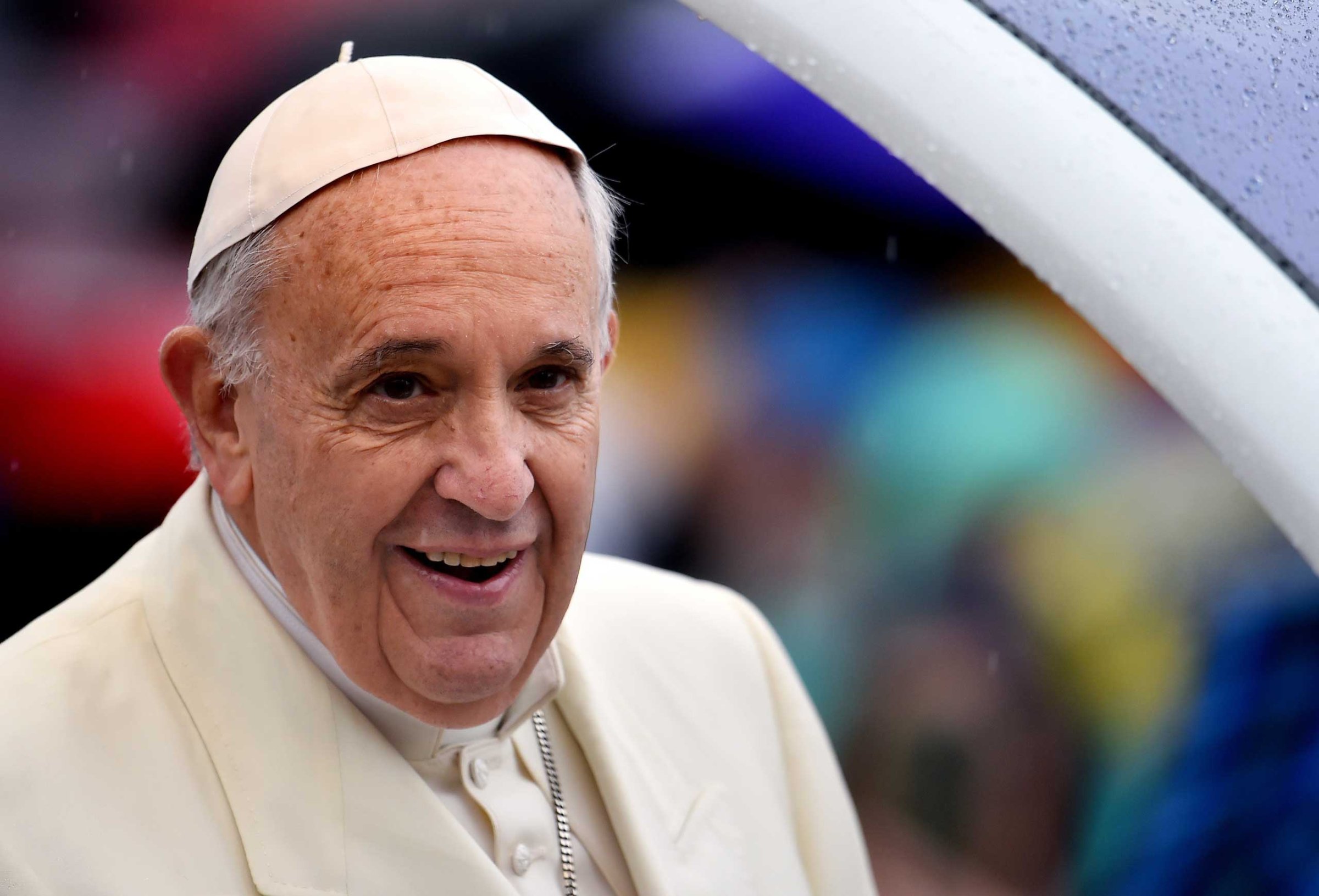 Pope Francis arrives under heavy rain, for his weekly general audience in St Peter's square at the Vatican on March 25, 2015.