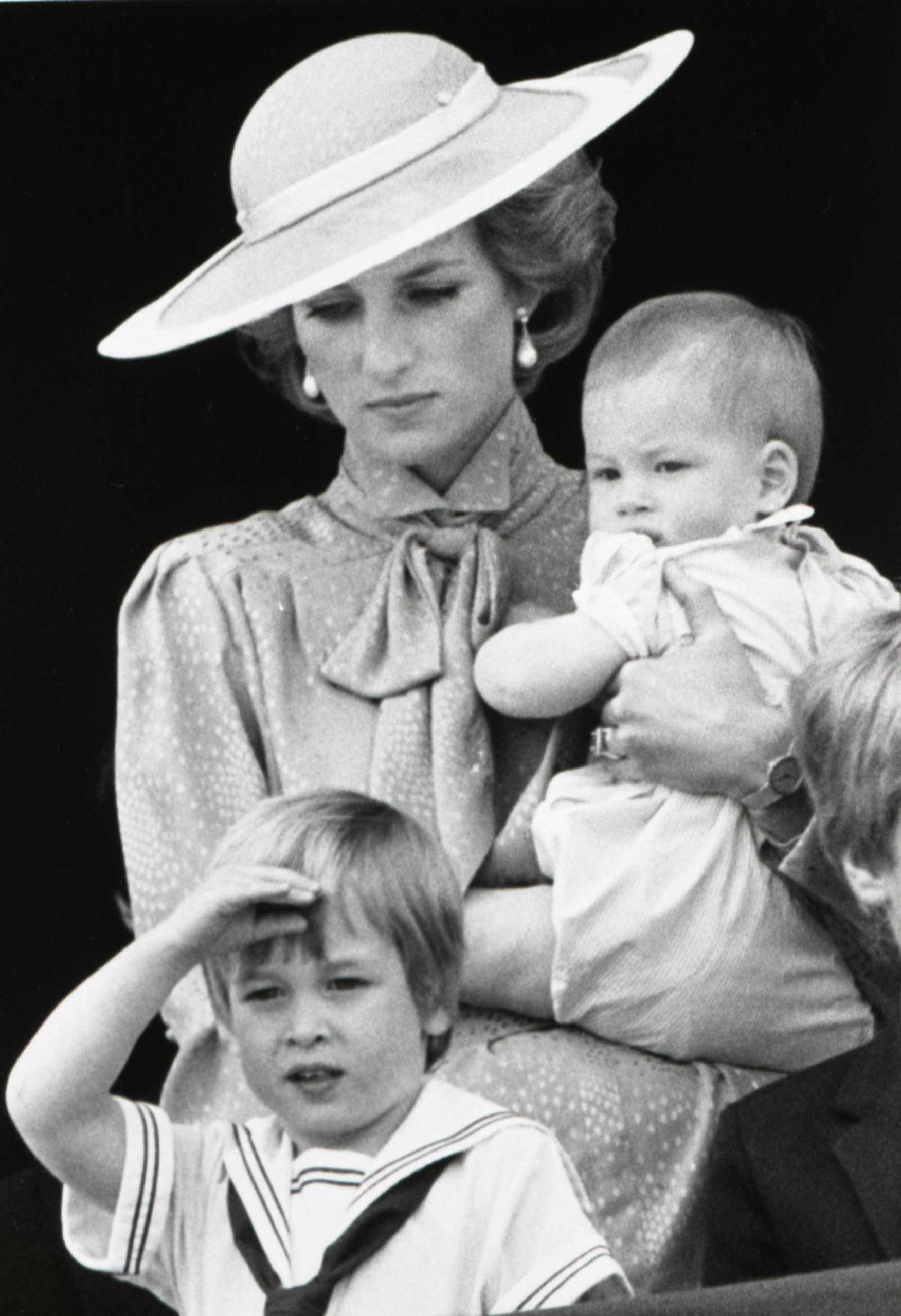 Prince Harry, aged 9 months, watches a military parade with his mother Diana, Princess of Wales, and brother William, in 1985.