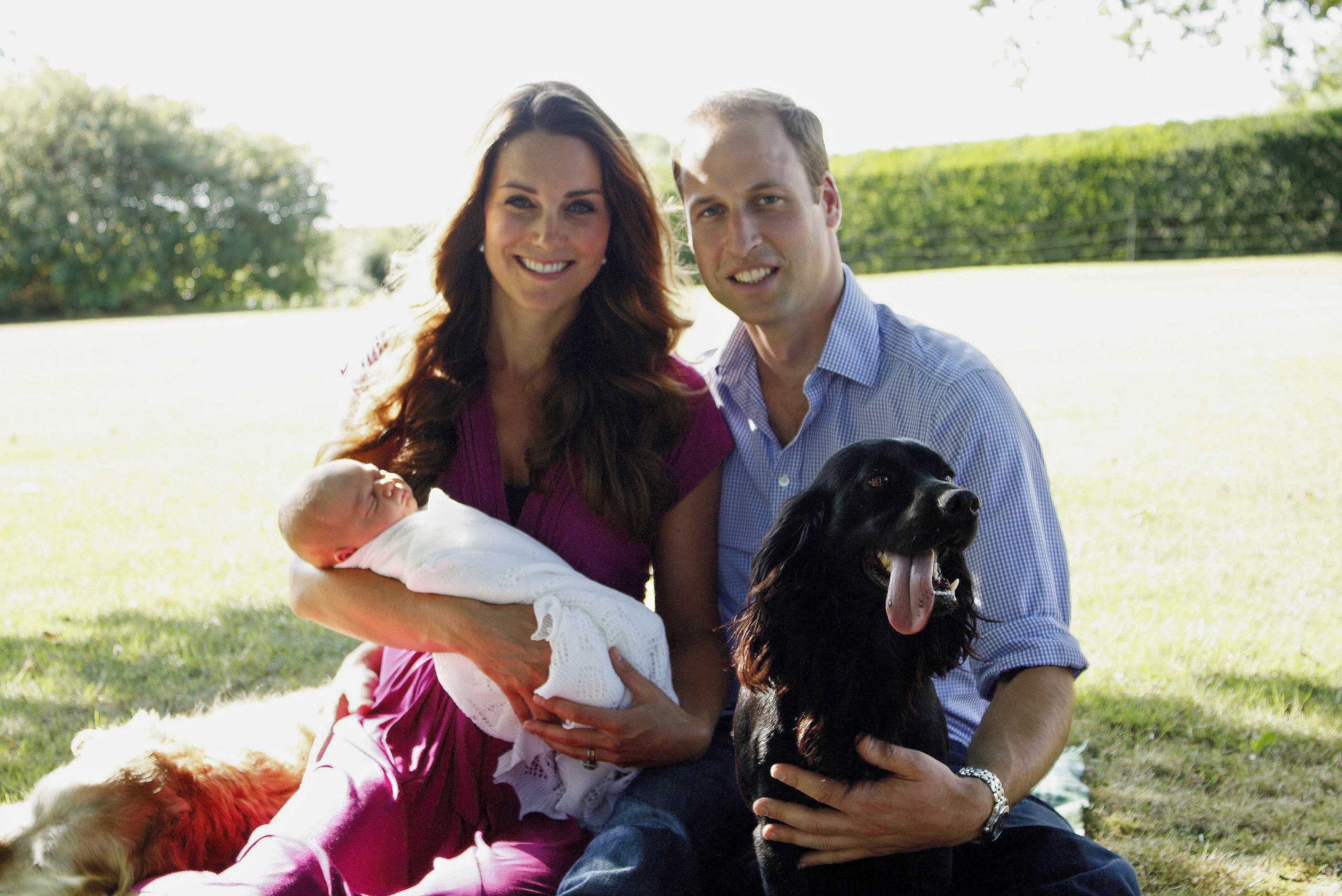Prince William, Duke of Cambridge, his wife Catherine, Duchess of Cambridge, with their newborn baby boy, Prince George of Cambridge, Tilly the retriever, left, a Middleton family pet and Lupo, the couple's cocker spaniel, right, at the Middleton family home in Bucklebury, Berkshire, in early August, 2013.
