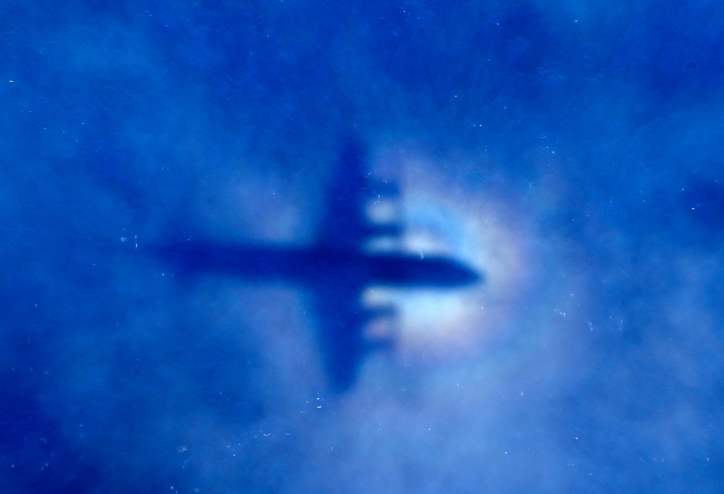 The shadow of a Royal New Zealand Air Force (RNZAF) P3 Orion maritime search aircraft can be seen on low-level clouds as it flies over the southern Indian Ocean looking for missing Malaysian Airlines flight MH370