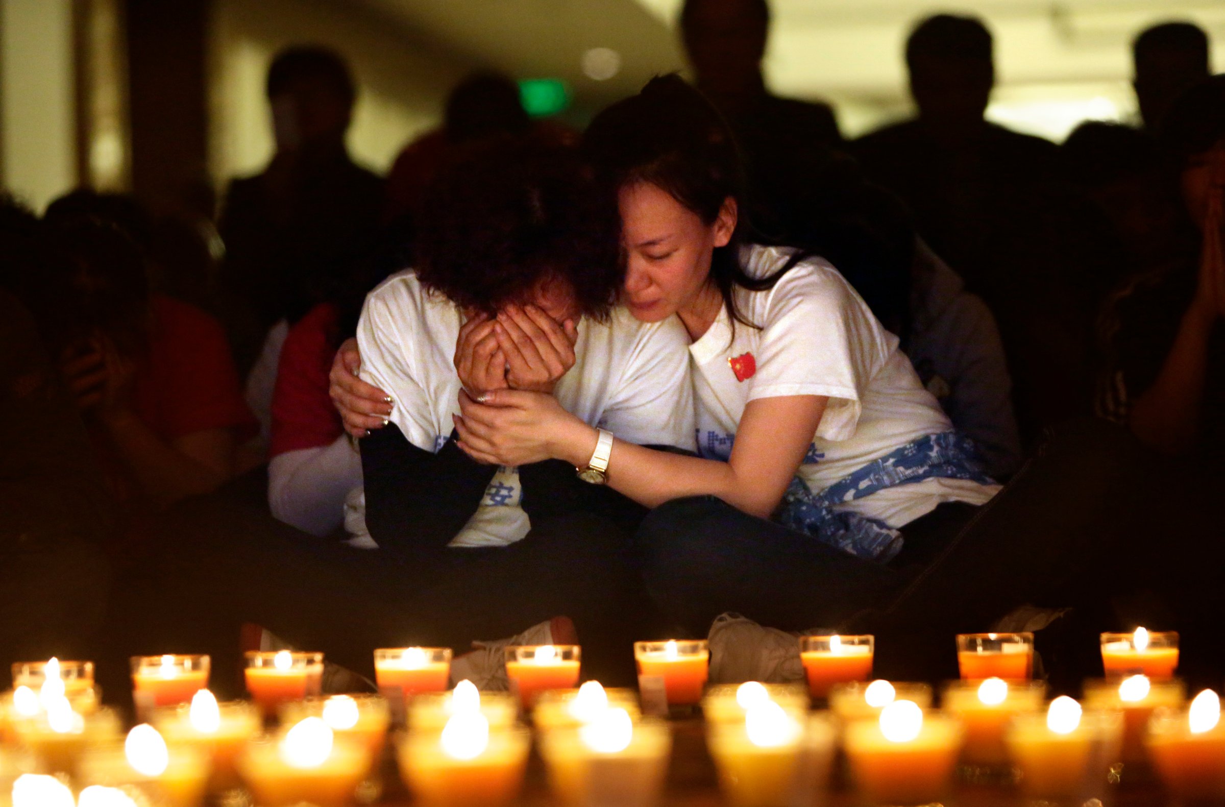 A family member cries as she and other relatives pray during a candlelight vigil for passengers onboard the missing Malaysia Airlines Flight MH370 in Beijing
