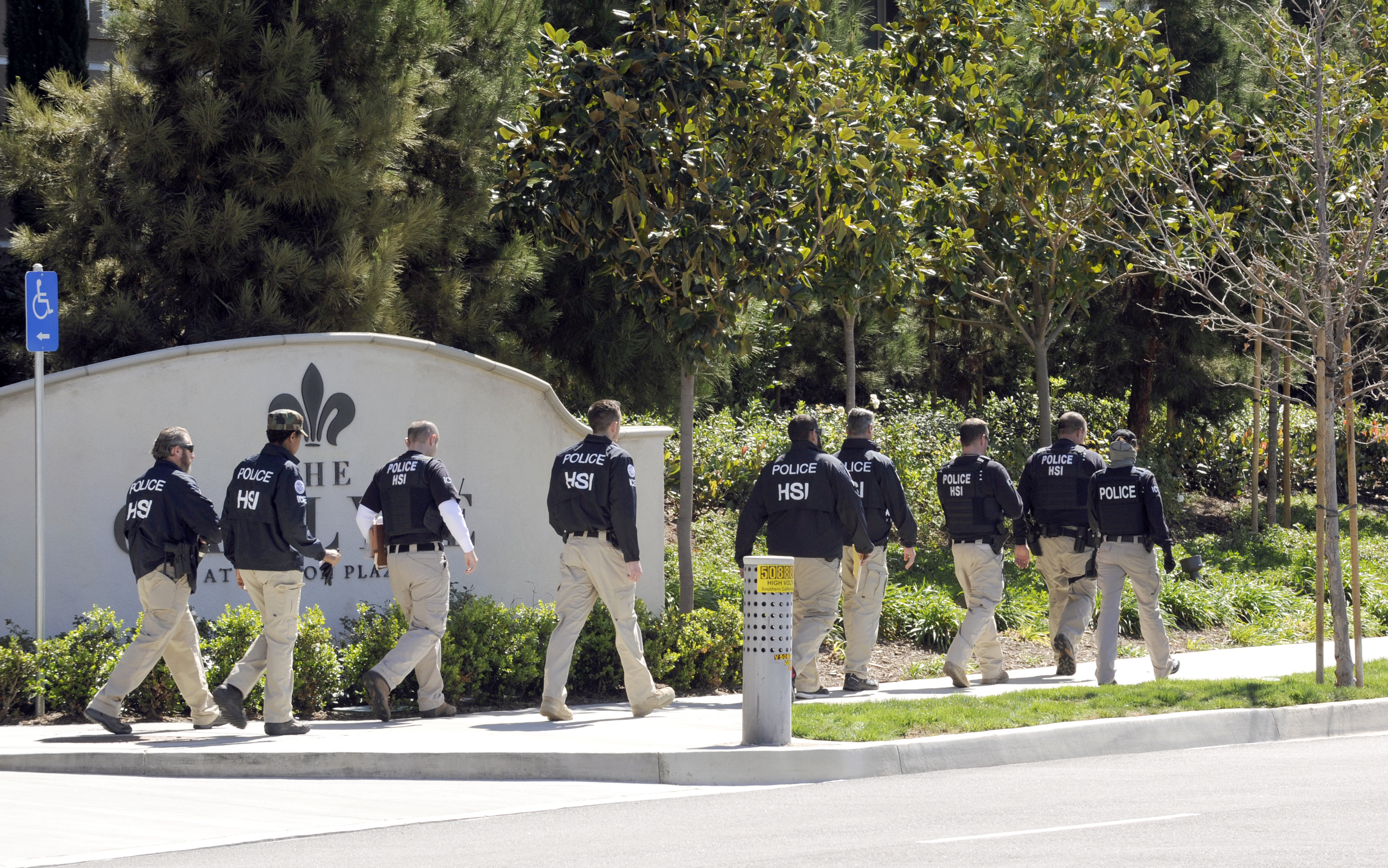 Federal agents walk past the Carlyle Apartments, the location of  a suspected "baby tourism operation," in Irvine, Calif. on March 3, 2015. (Bob Riha Jr.—Reuters)