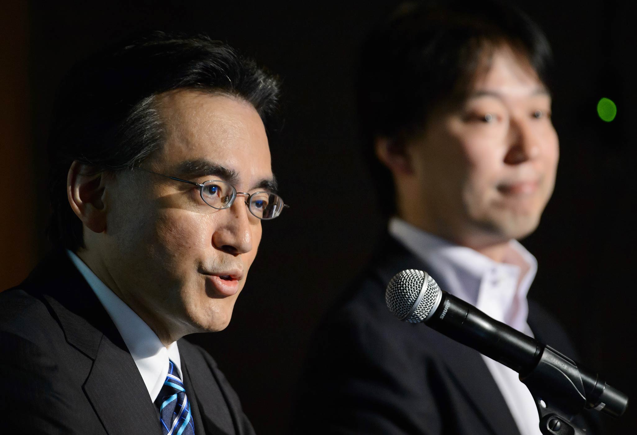 Nintendo President and CEO Satoru Iwata, left, speaks while DeNA Co. President and CEO Isao Moriyasu listens during a joint news conference in Tokyo, Japan, on March 17, 2015. (Akio Kon—Bloomberg/Getty Images)