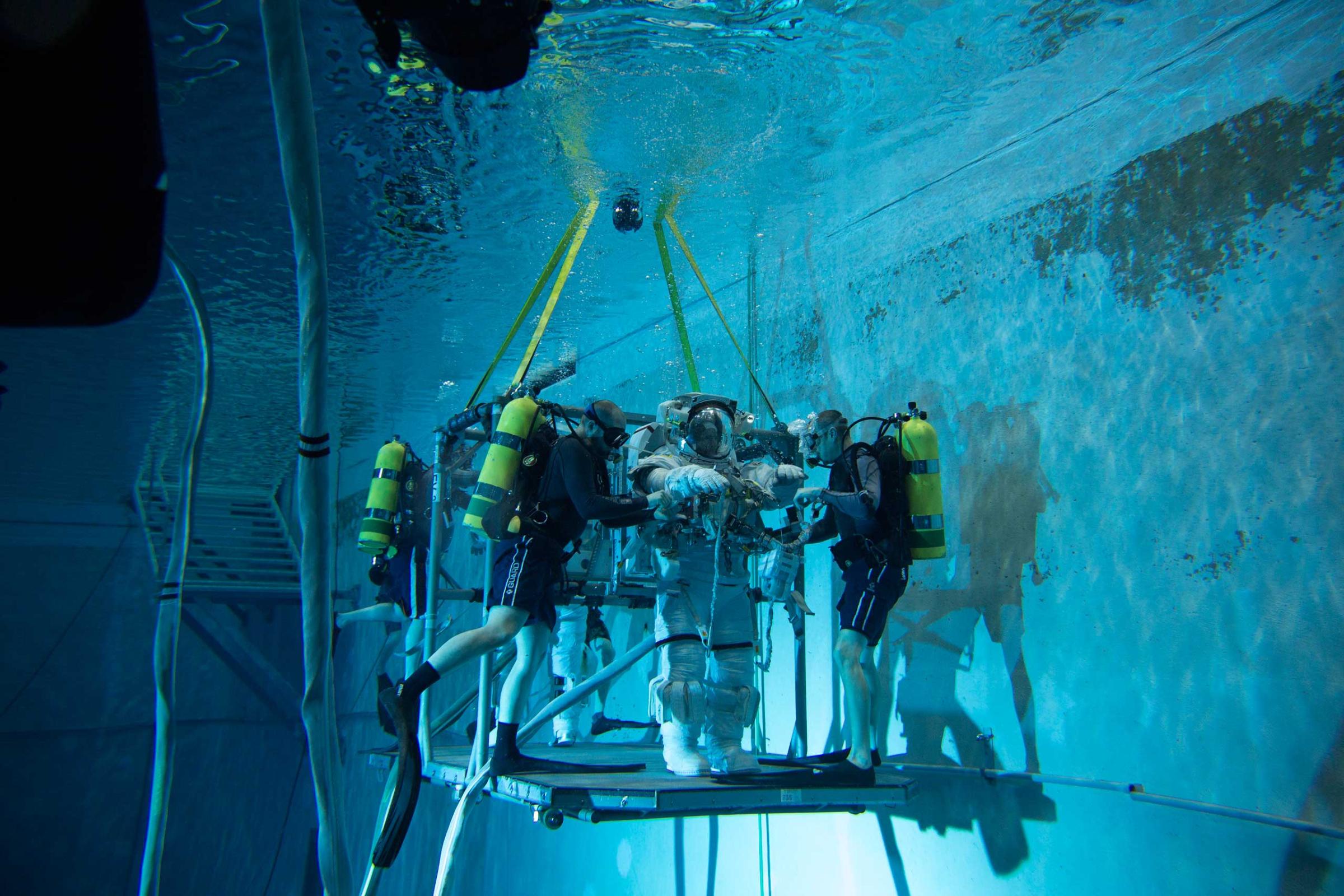 Divers check Scott Kelly's suit for leaks as he prepares for underwater training on in Houston on Feb. 2. Even though the spacesuit weighs more than Scott, due to the air inside it, he does not sink like a rock in the pool, but instead becomes neutrally buoyant, simulating weightlessness.