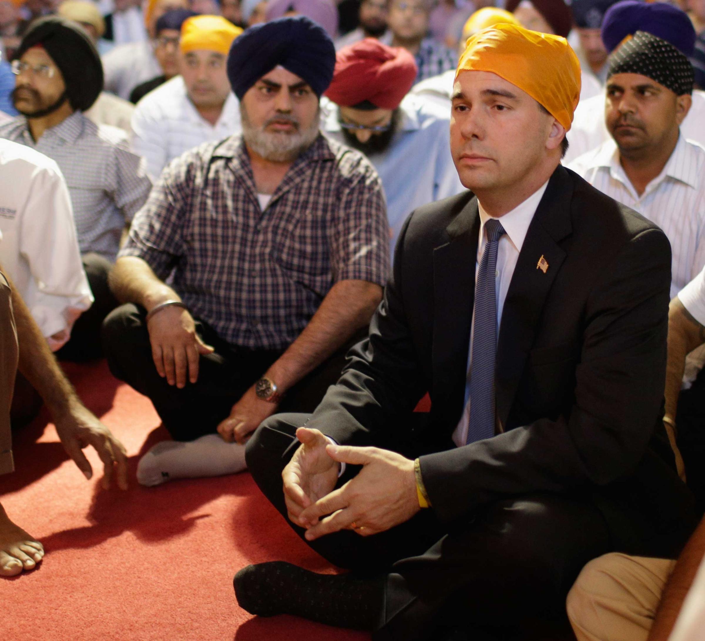 Wisconsin Governor Scott Walker attends a prayer service at the Sikh Temple in Brookfield, Wis., on August 6, 2012.
