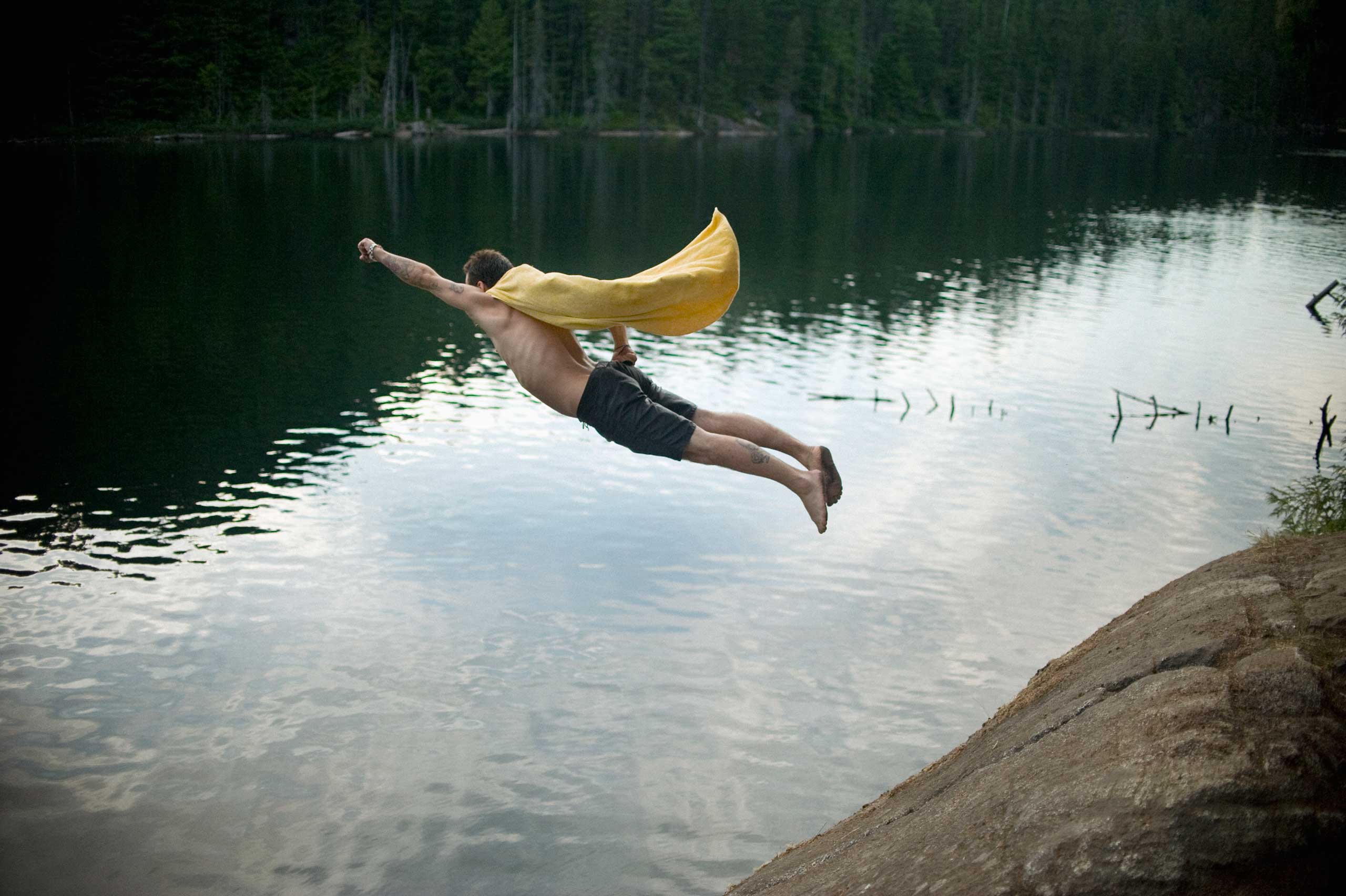Full length of man dressed as superhero jumping in Brohm lake