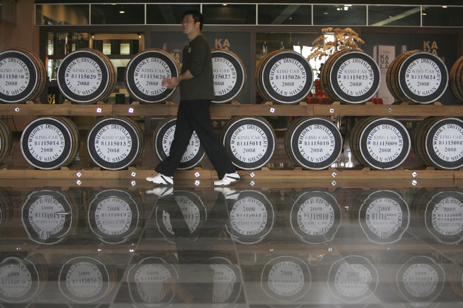 A visitor walks past casks at the Kavalan whiskey distillery in Yilan County, Taiwan (Wally Santana—AP)