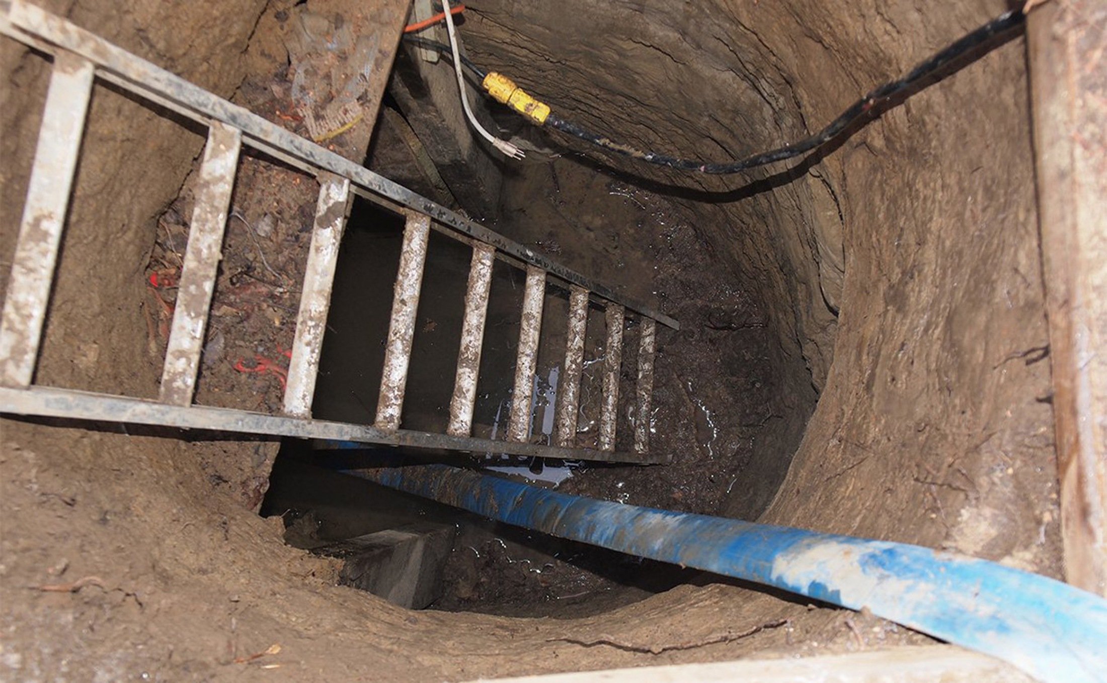 File photo of a ladder leading to a 33-foot-long tunnel supported using lumber which was found in Toronto