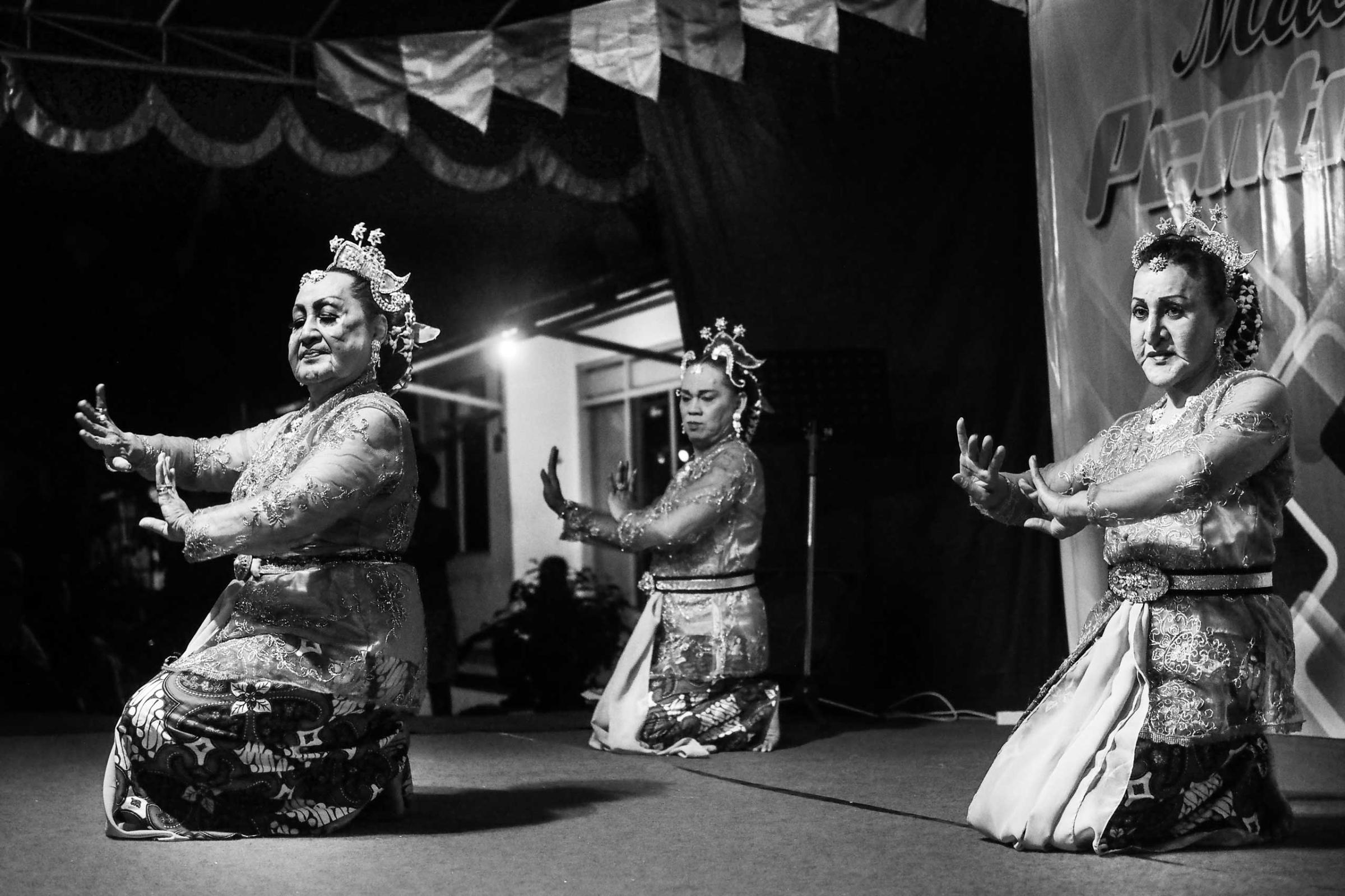 Shinta Ratri performs a Balinese dance wearing a typical dress with two other transgender friends at a local street festival in Yogyakarta.