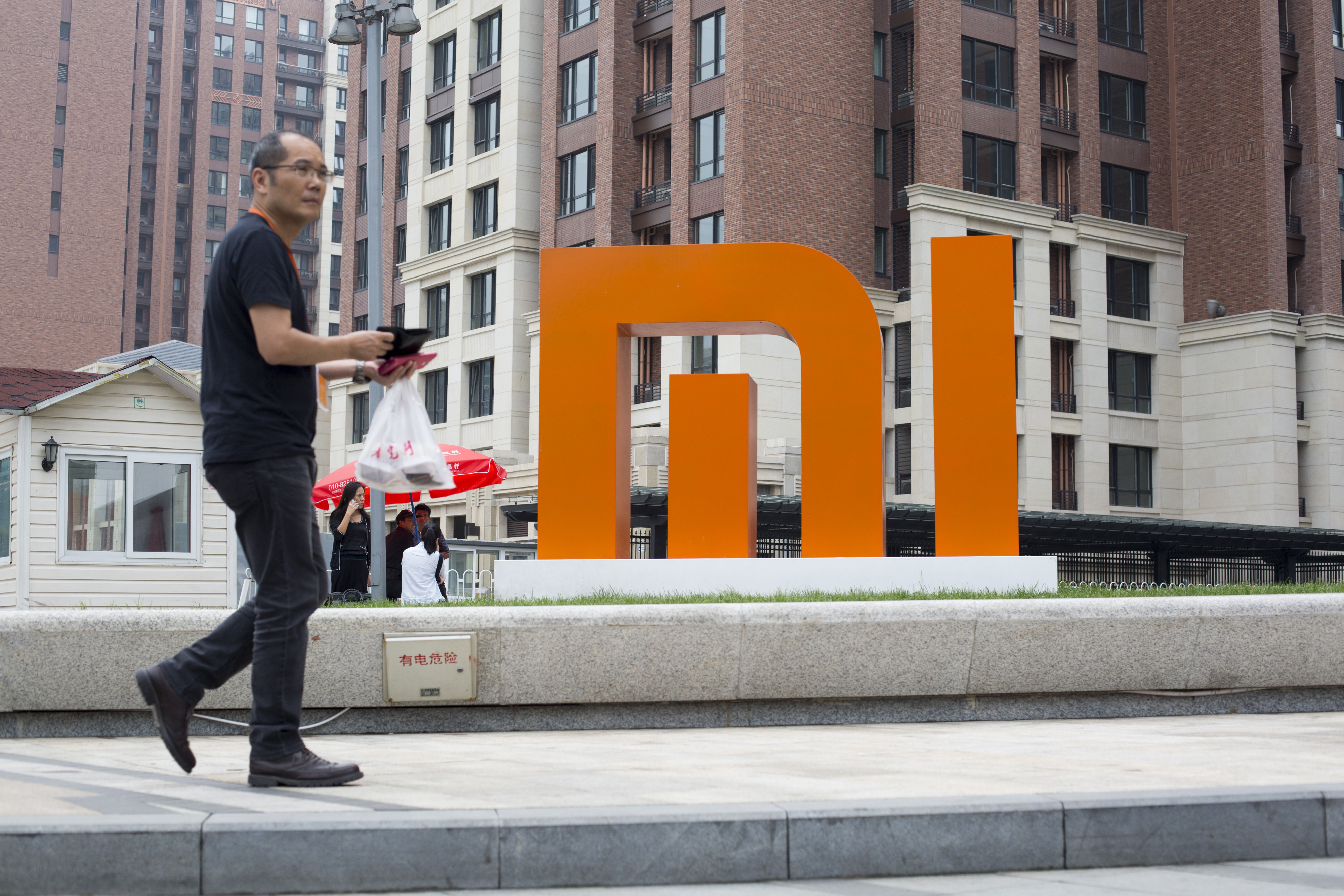 A man walks past a Xiaomi Corp. logo displayed outside the company's headquarters in Beijing, China, on Sept. 12, 2014. (Bloomberg via Getty Images)
