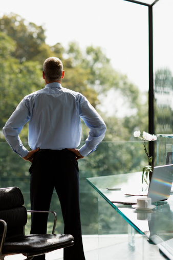 businessman-standing-looking-out-window