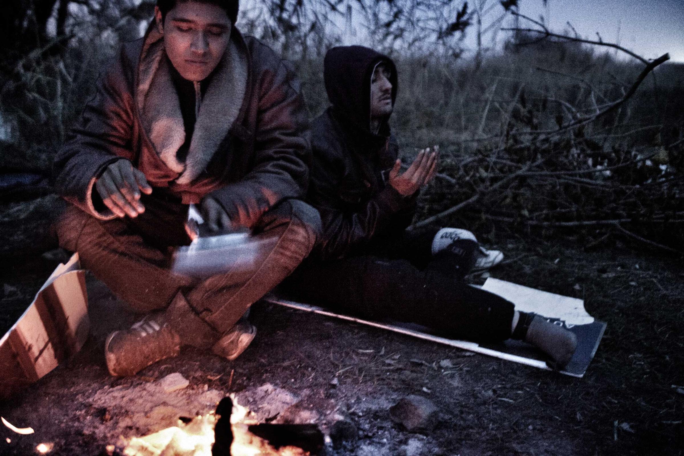Afghan refugees, Kabir and Zaher, sit by a fire in Subotica, Serbia on Nov. 10, 2012. Zaher, who lost his left leg below the knees, made it to Serbia on crutches. Zaher says he is 16 and Kabir 15. The two were traveling together from Greece. The men they lived outdoors in Subotica, waiting for smugglers to give the green light to continue their journey.