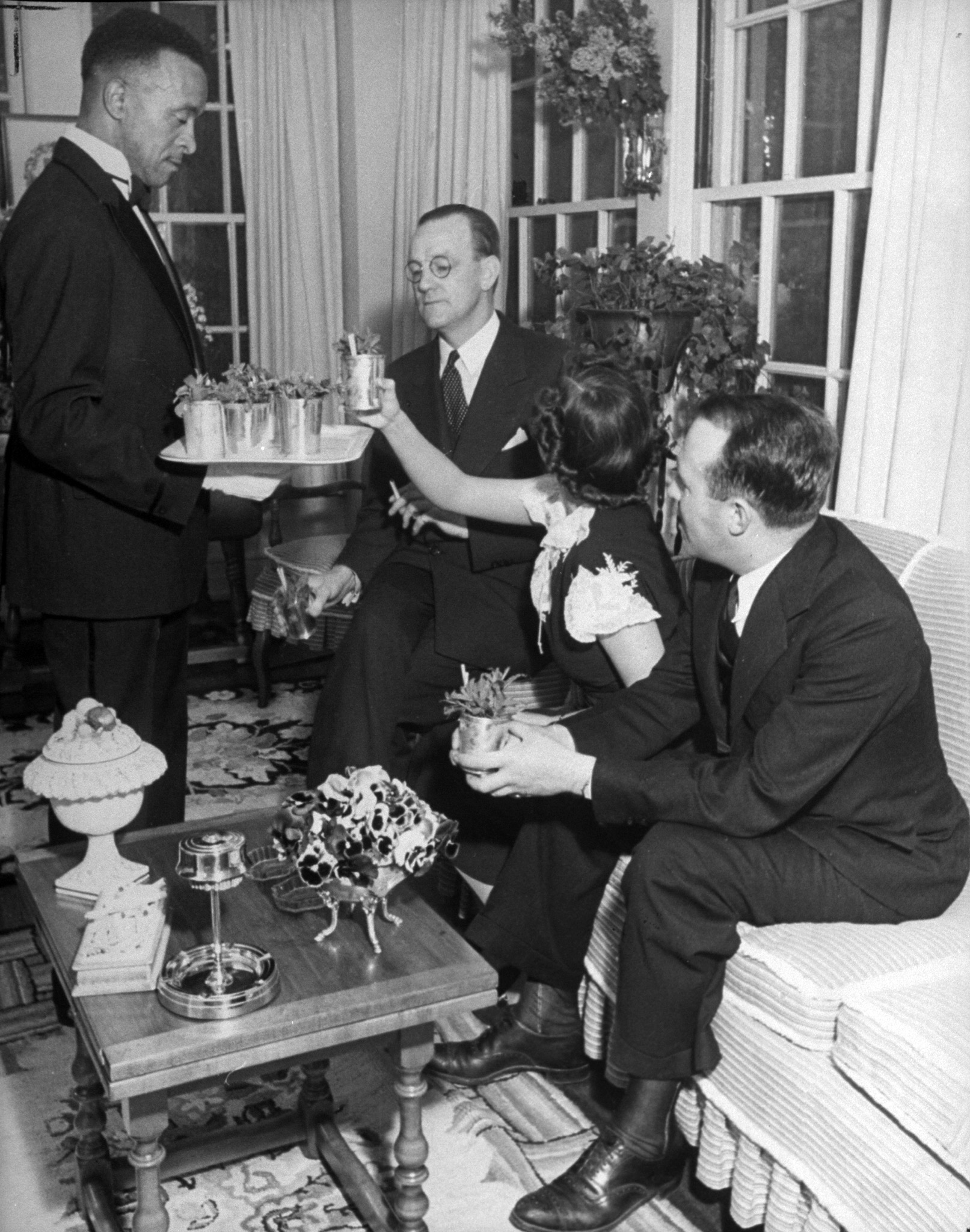 Congenial celebrants at the Van Winkle mint julep party included, from left to right, T. V. Hartnett, tobacco bigwig; Mary Van Winkle, the host's daughter; Richard Dewey.