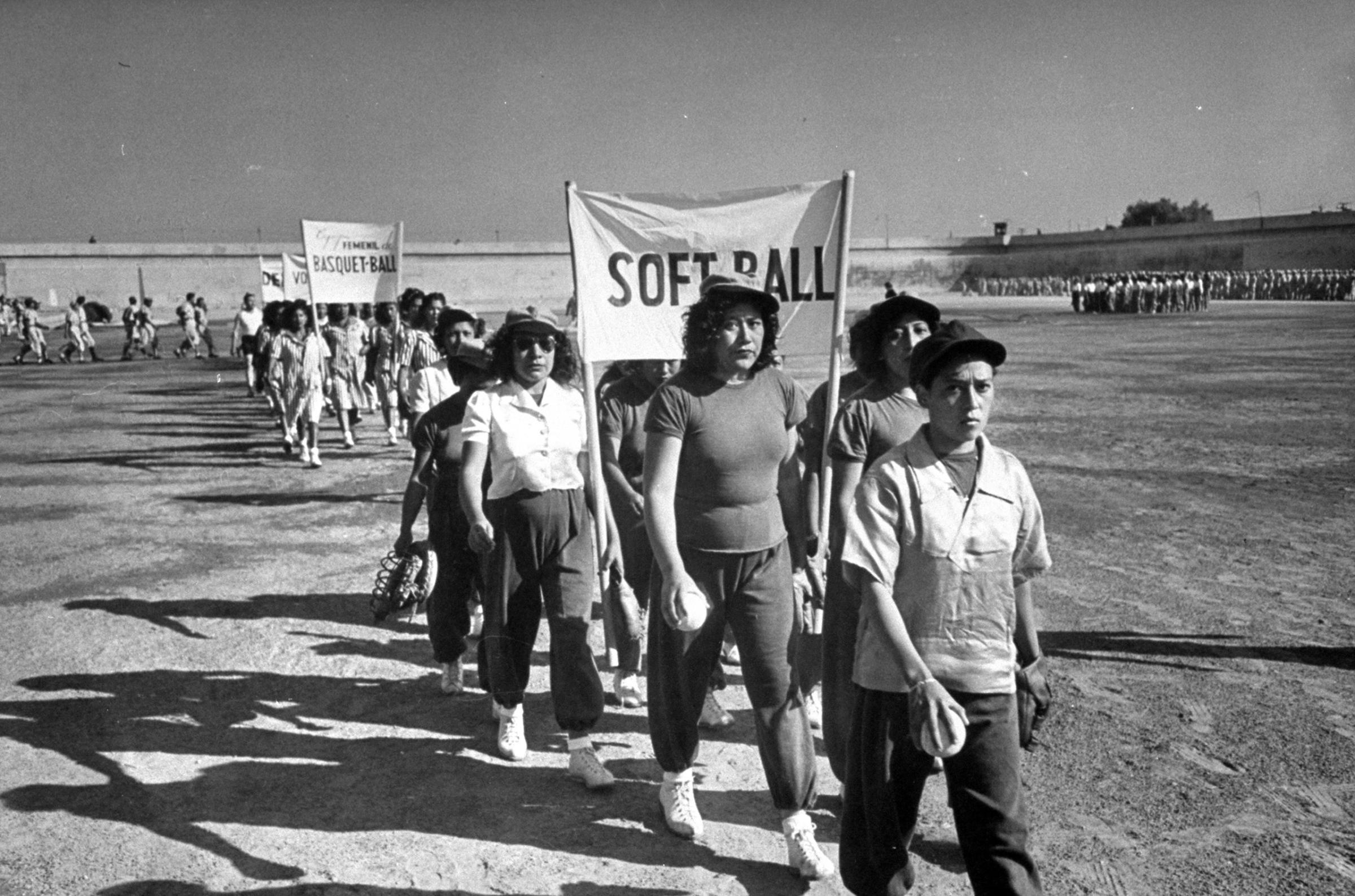 Prison athletes, led by women, parade around the athletic field. They play intramural games and also meet teams from a Mexico City normal school.