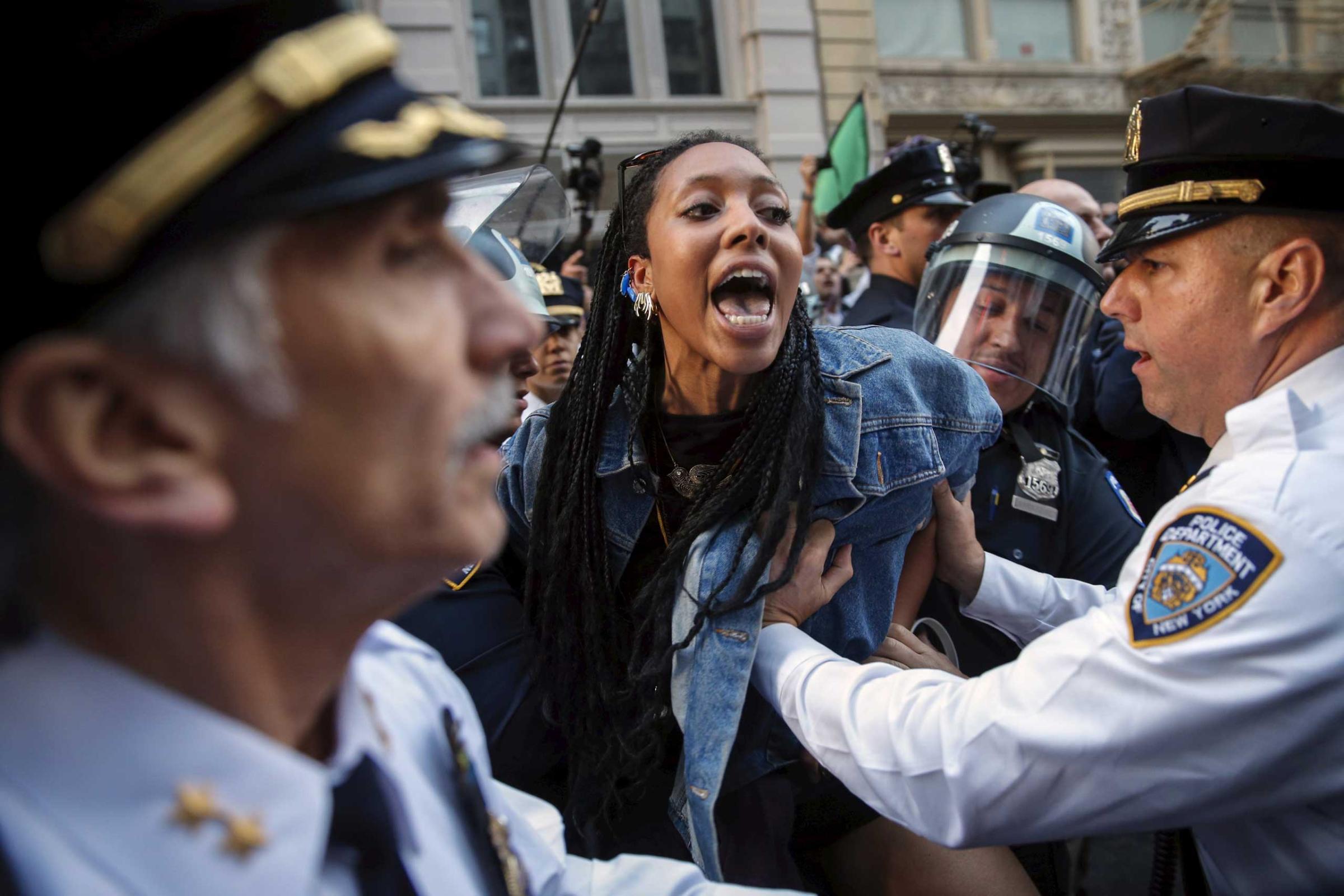 New York Police Department officers detain a protester during a march through the Manhattan borough of New York City on April 29, 2015.