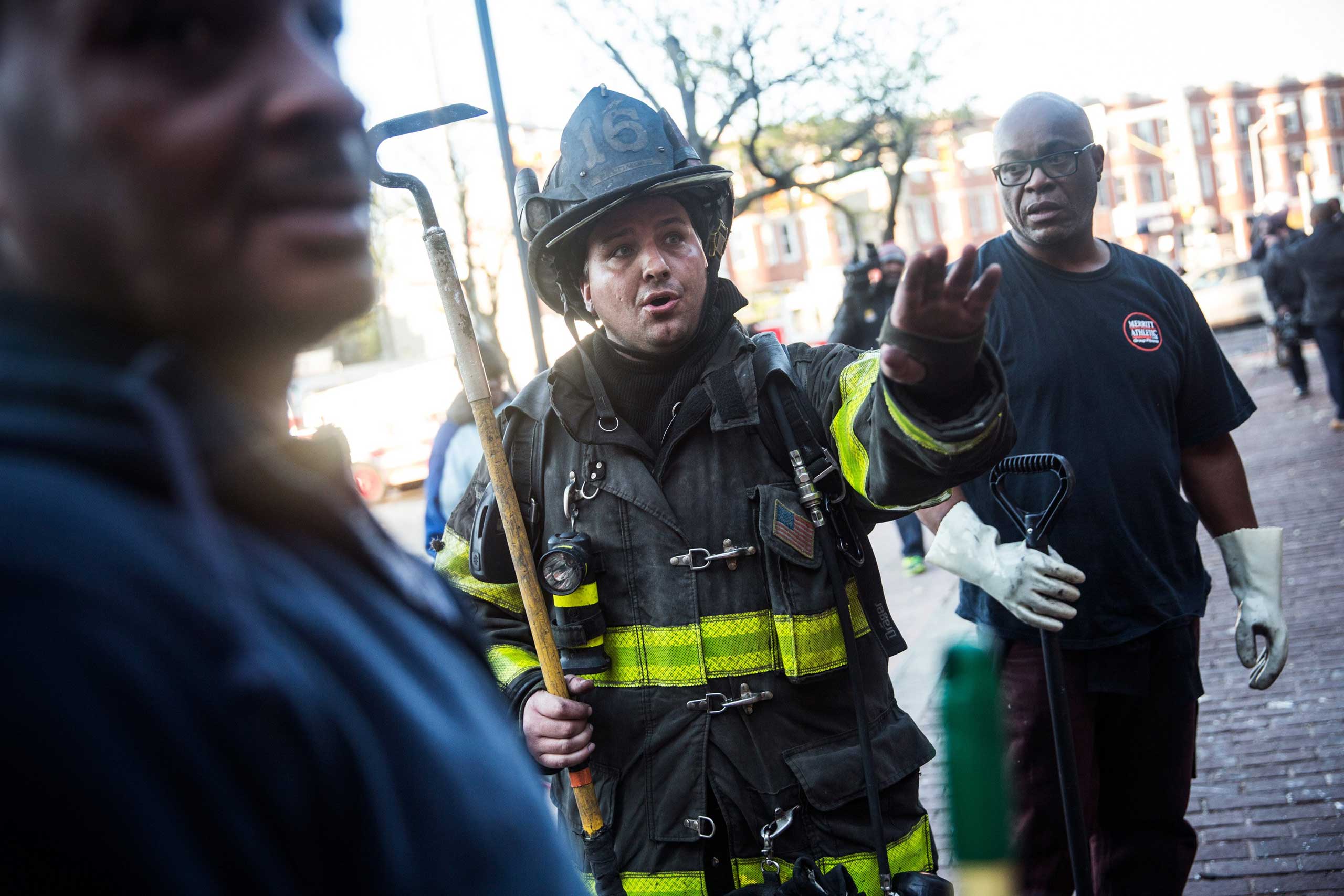 Baltimore firefighters talk to community members cleaning up a CVS pharmacy that was set on fire one day earlier during riots in Baltimore, April 28, 2015.