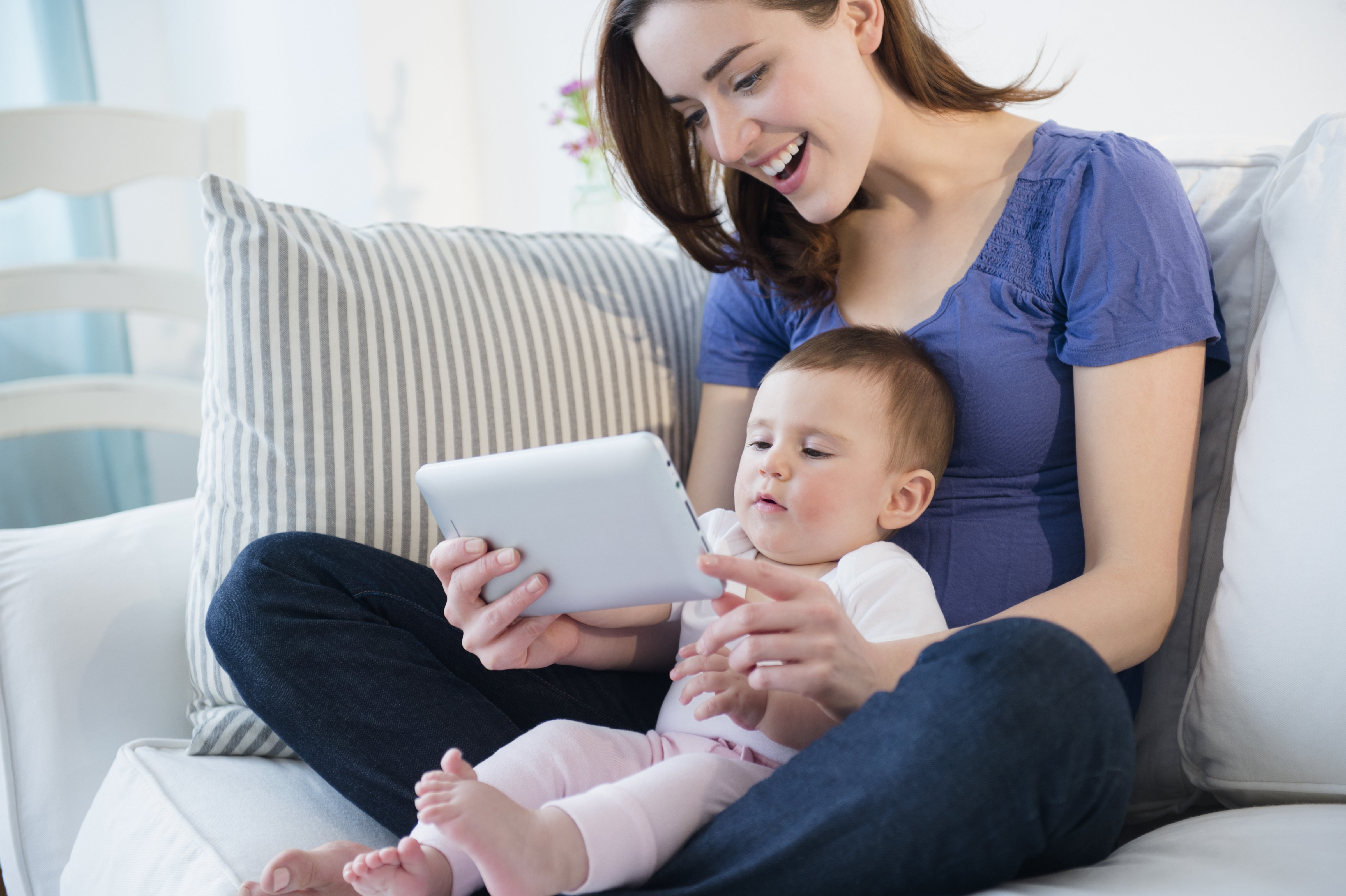 Mother and baby using digital tablet (JGI/Jamie Grill&mdash;Getty Images/Blend Images)