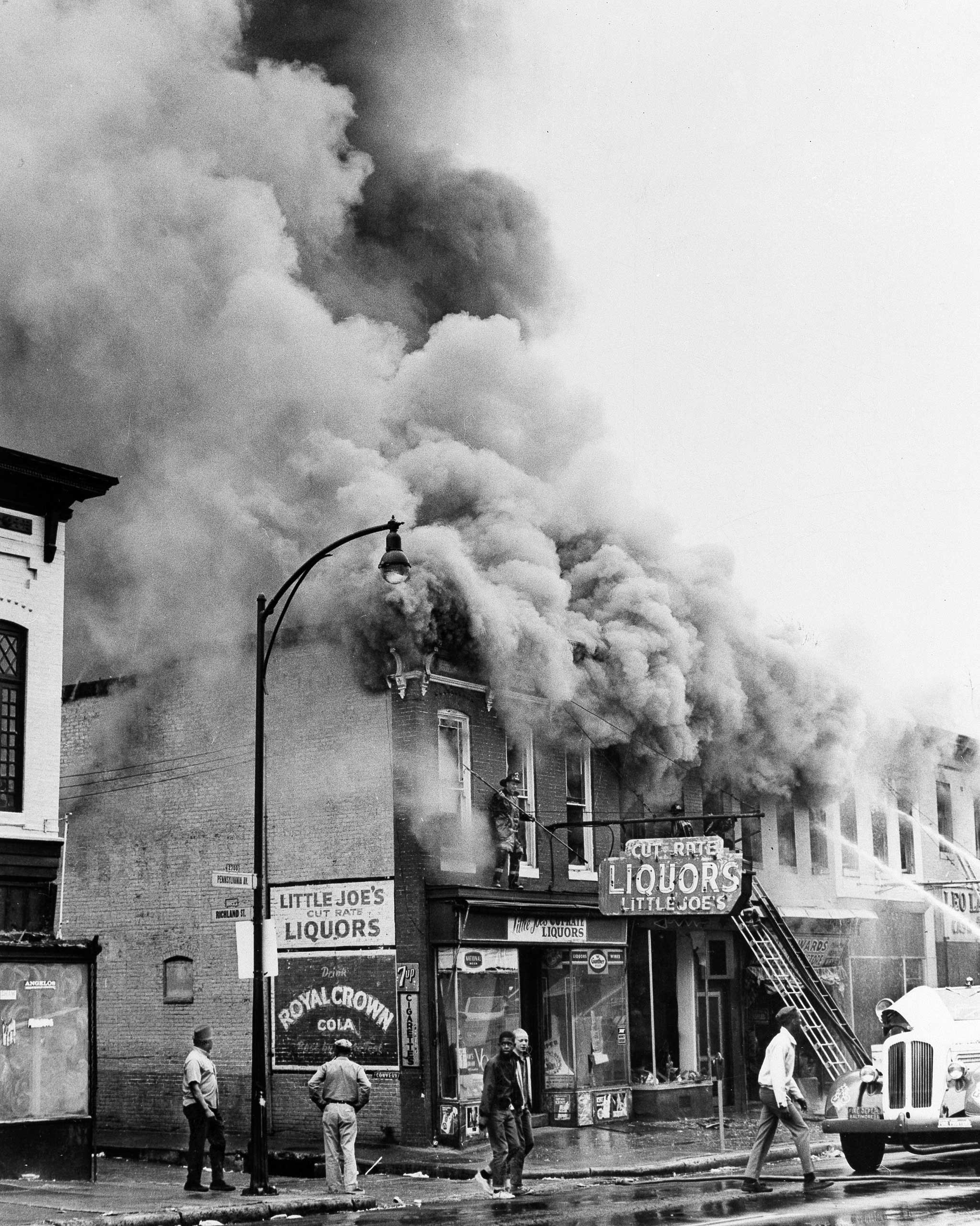 Smoke billows from a liquor store which was looted during the third day of violence, which saw over 400 fires, in Baltimore on April 8, 1968.