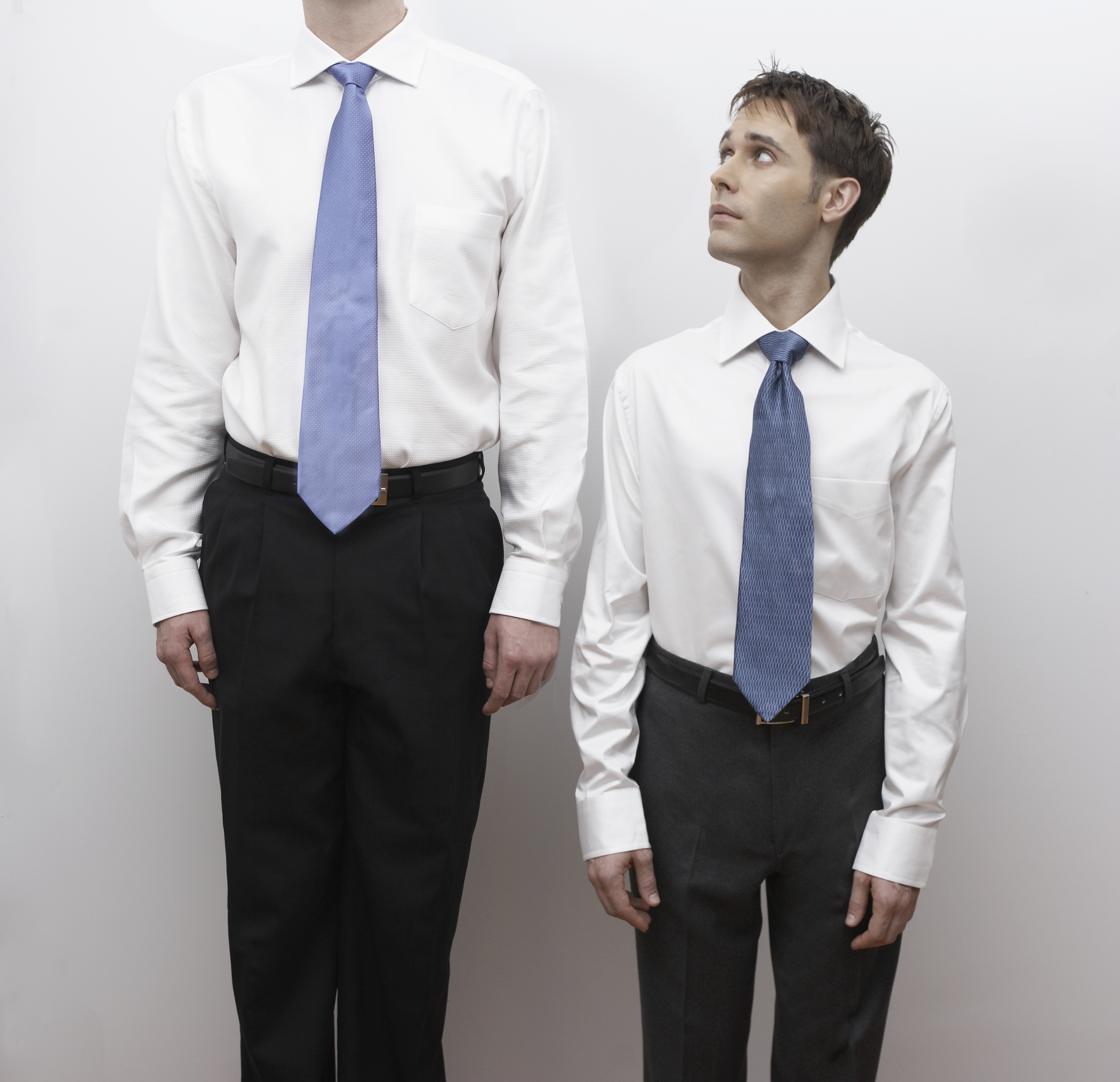 Short business man standing next to tall man (Roy Hsu—Getty Images/Uppercut)