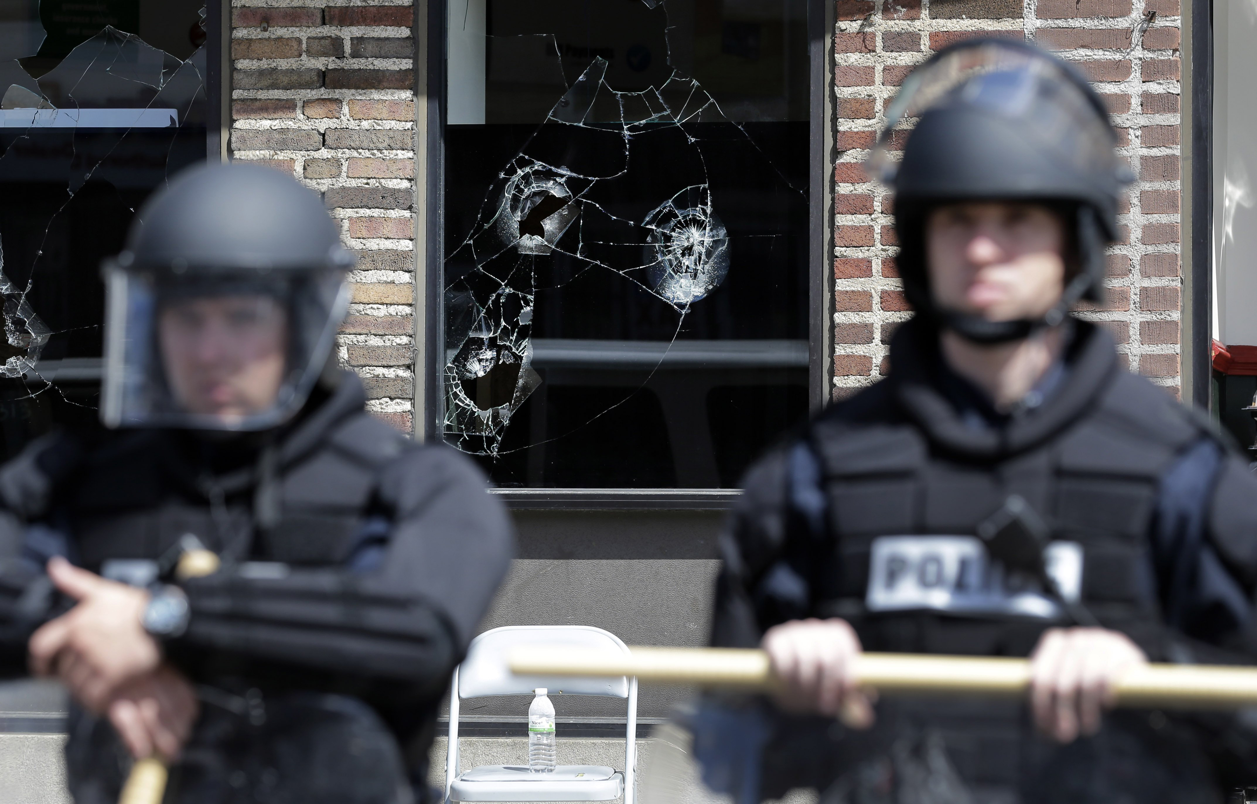 Broken store windows remain as members of the Anne Arundel County Police guard the intersection of North Avenue and Pennsylvania Avenue, on April 29, 2015, in Baltimore. (Patrick Semansky—AP)
