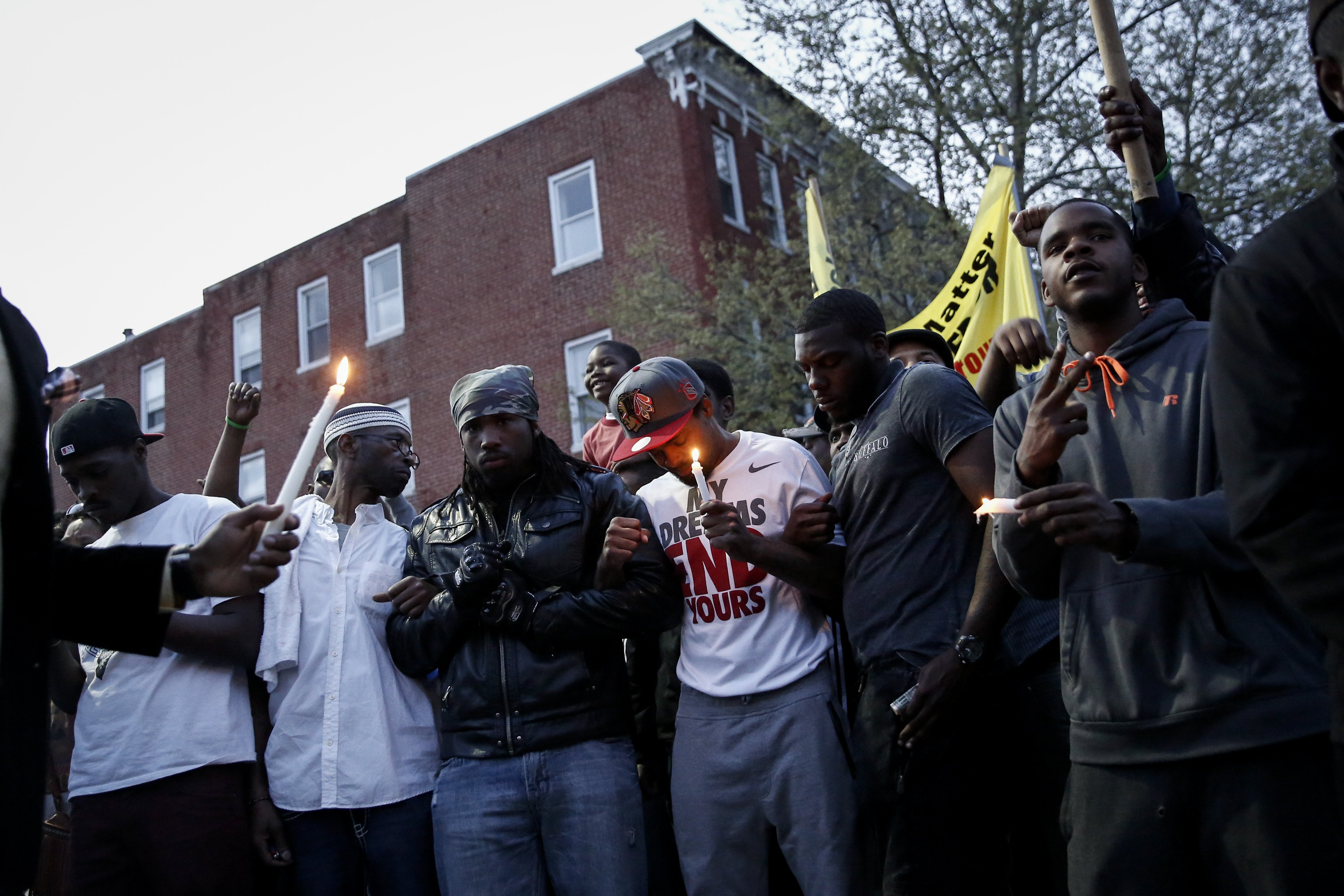 Protestors participate in a vigil for Freddie Gray down the street from the Baltimore Police Department's Western District police station in Baltimore on April 21, 2015.