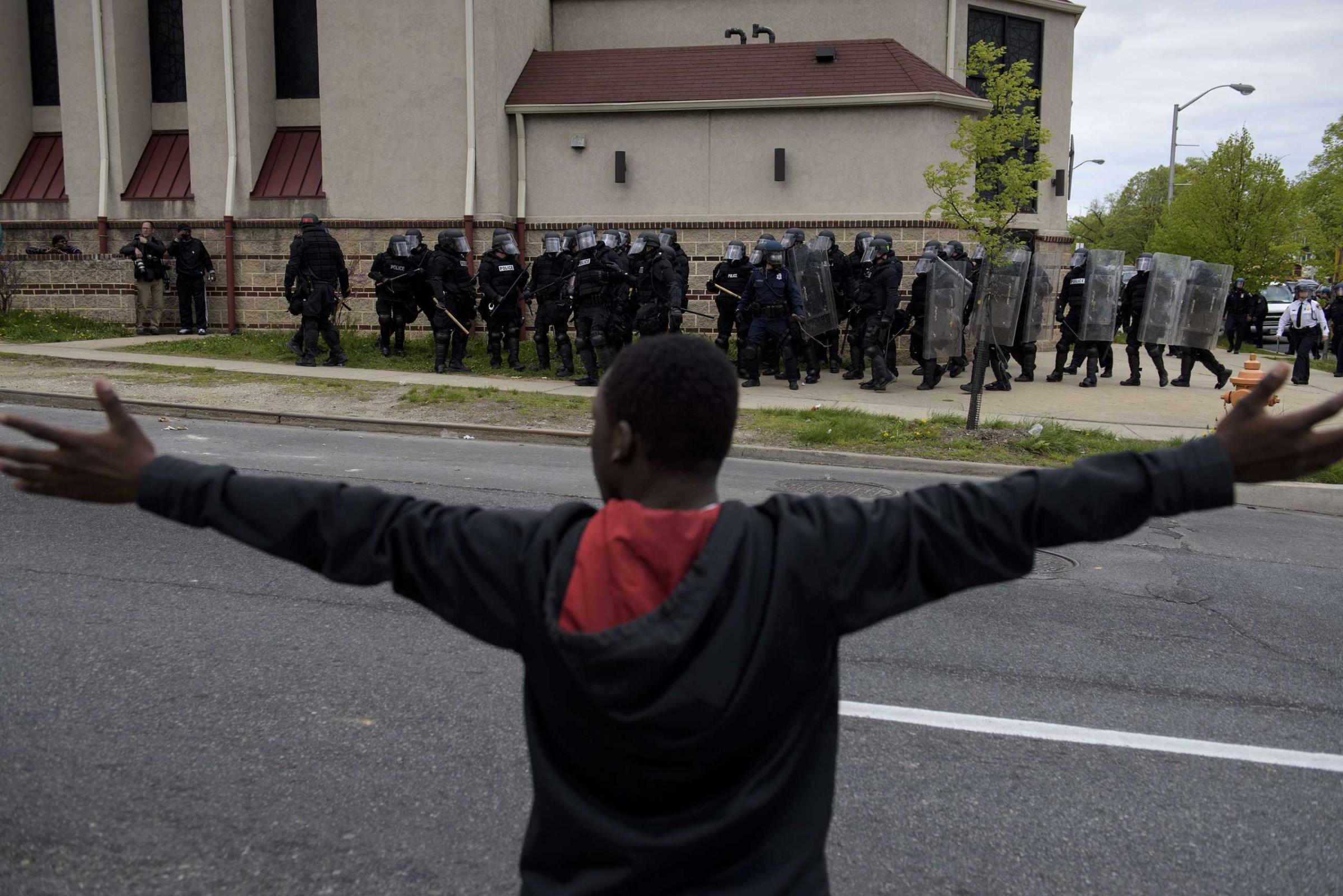 Baltimore police officers form a line in front of protesters near Mondawmin Mall in Baltimore on April 27, 2015.