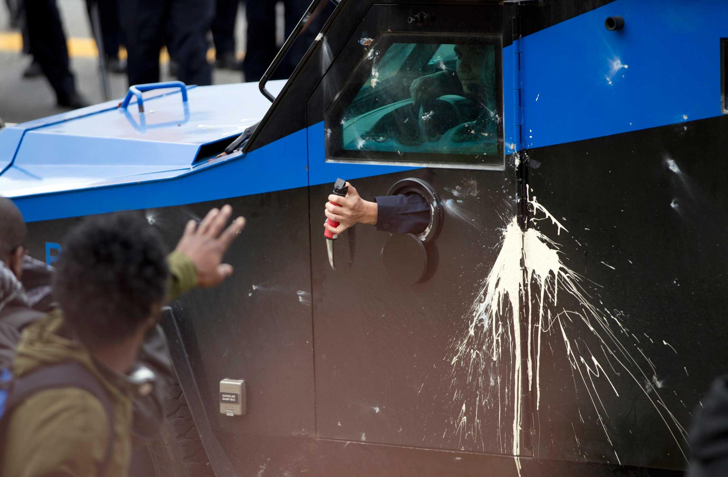 Police officers use pepper spray against demonstrators after the funeral of Freddie Gray in Baltimore on April 27, 2015.