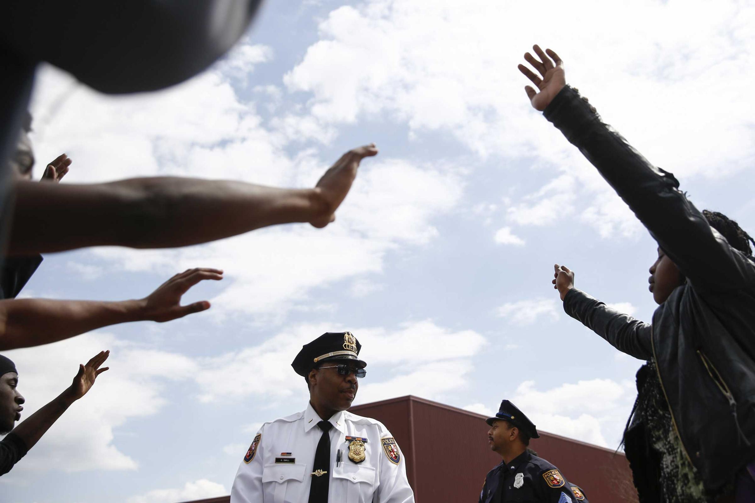 Protesters surround a police officer near Mondawmin Mall in Baltimore on April 27, 2015.