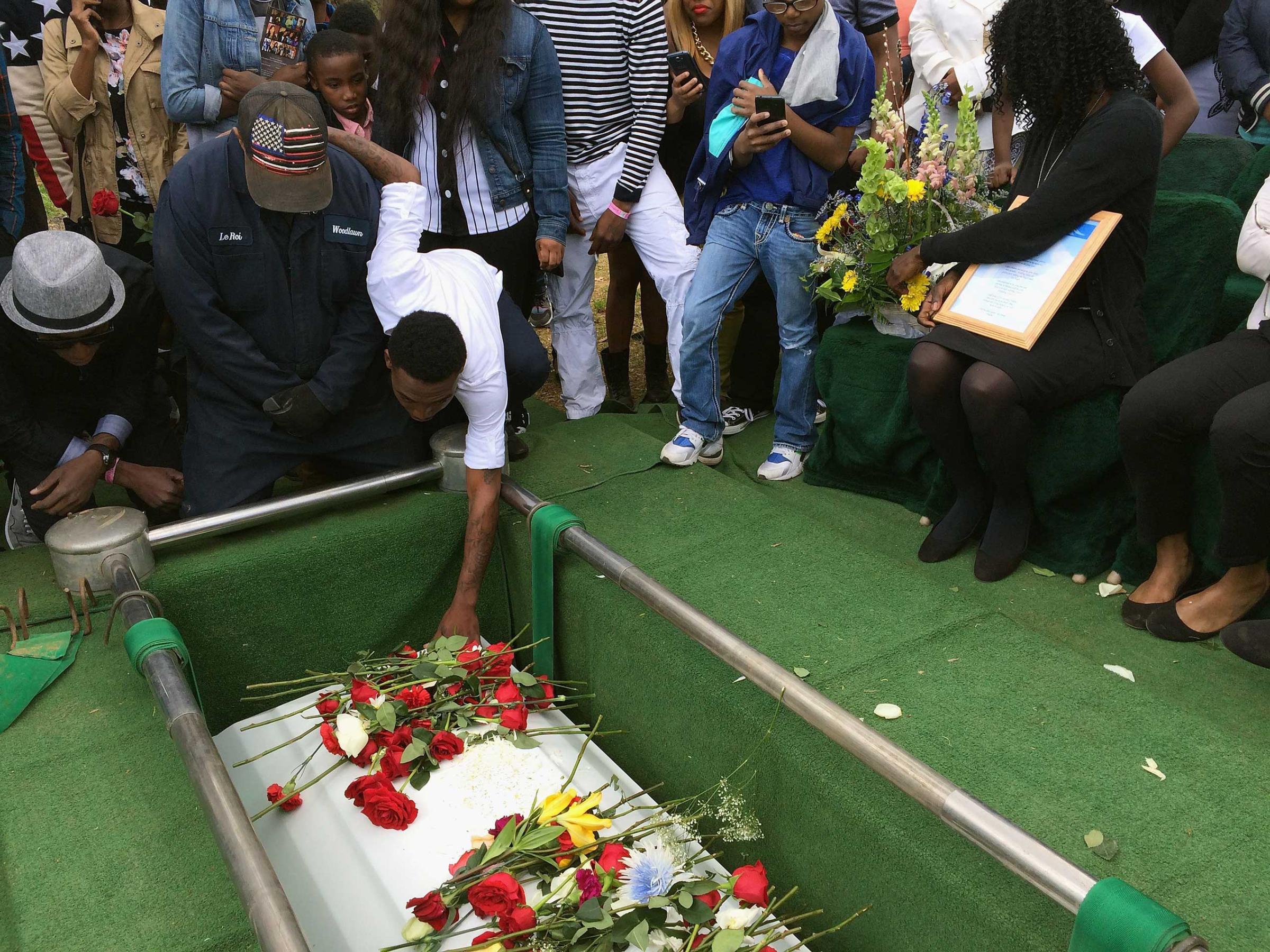 Friends and relatives say their last goodbyes to Freddie Gray as his casket is lowered into his grave at the Woodland Cemetery in Baltimore on April 27, 2015.