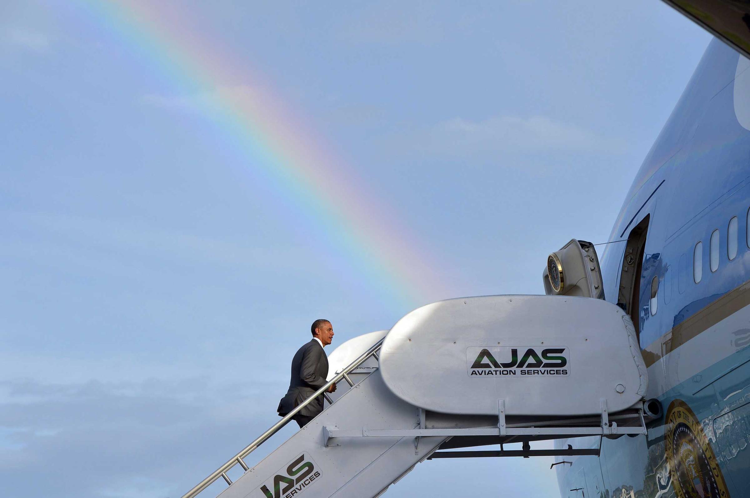 US President Barack Obama makes his way to board Air Force One under a rainbow upon departure from Kingston, Jamaica on April 9, 2015.