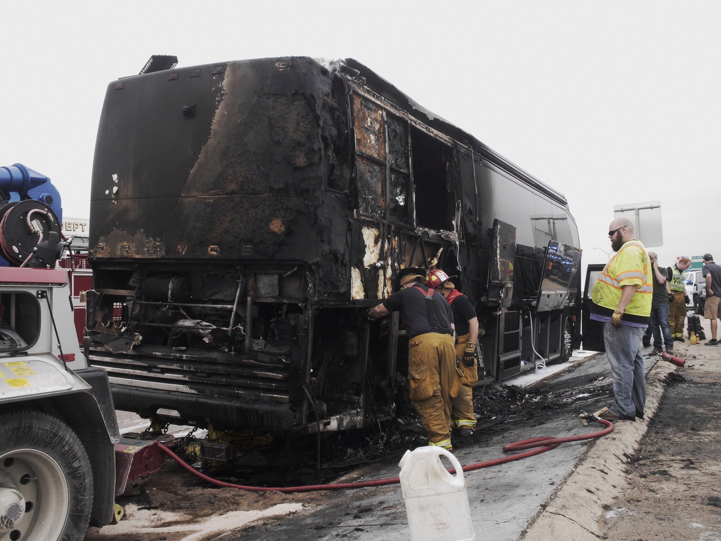Firemen look at the damage after a fire on Lady Antebellum's bus on eastbound I-30 in Garland, Texas