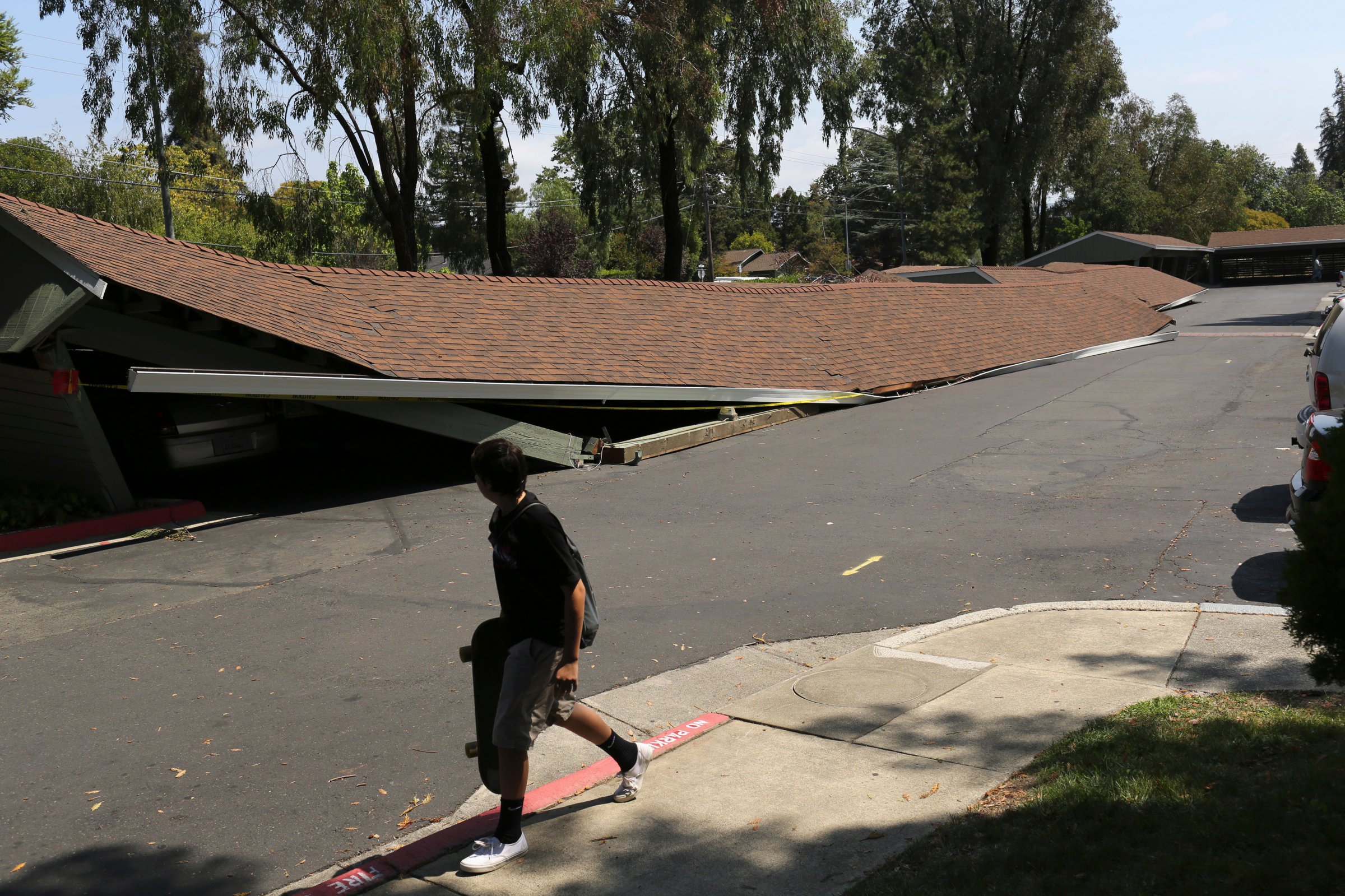 A youngster walks past a parking structure that collapsed during Sunday's 6.0 earthquake in Napa, California August 25, 2014