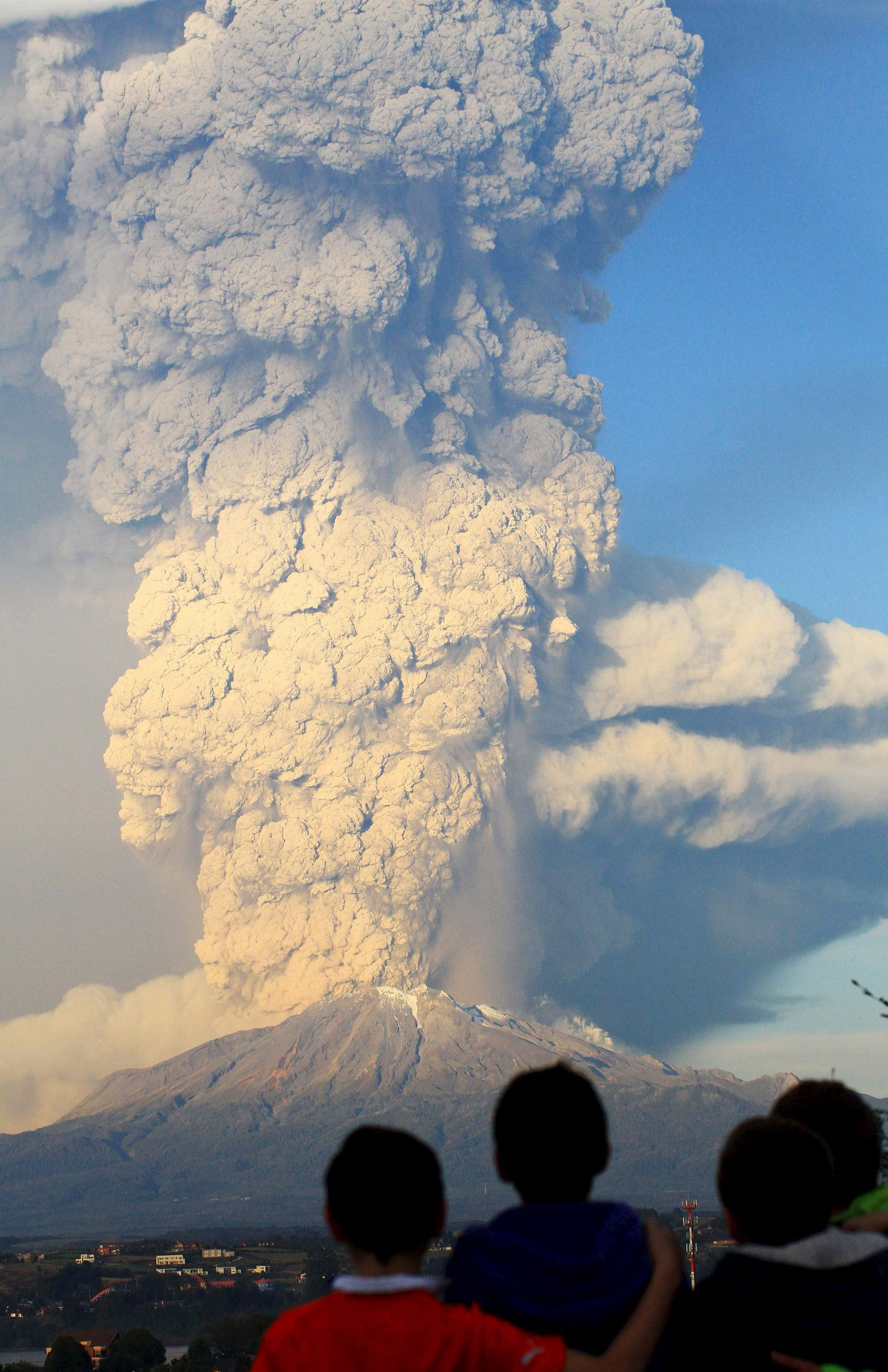Children from Puerto Varas look on as ash rises from the Calbuco volcano