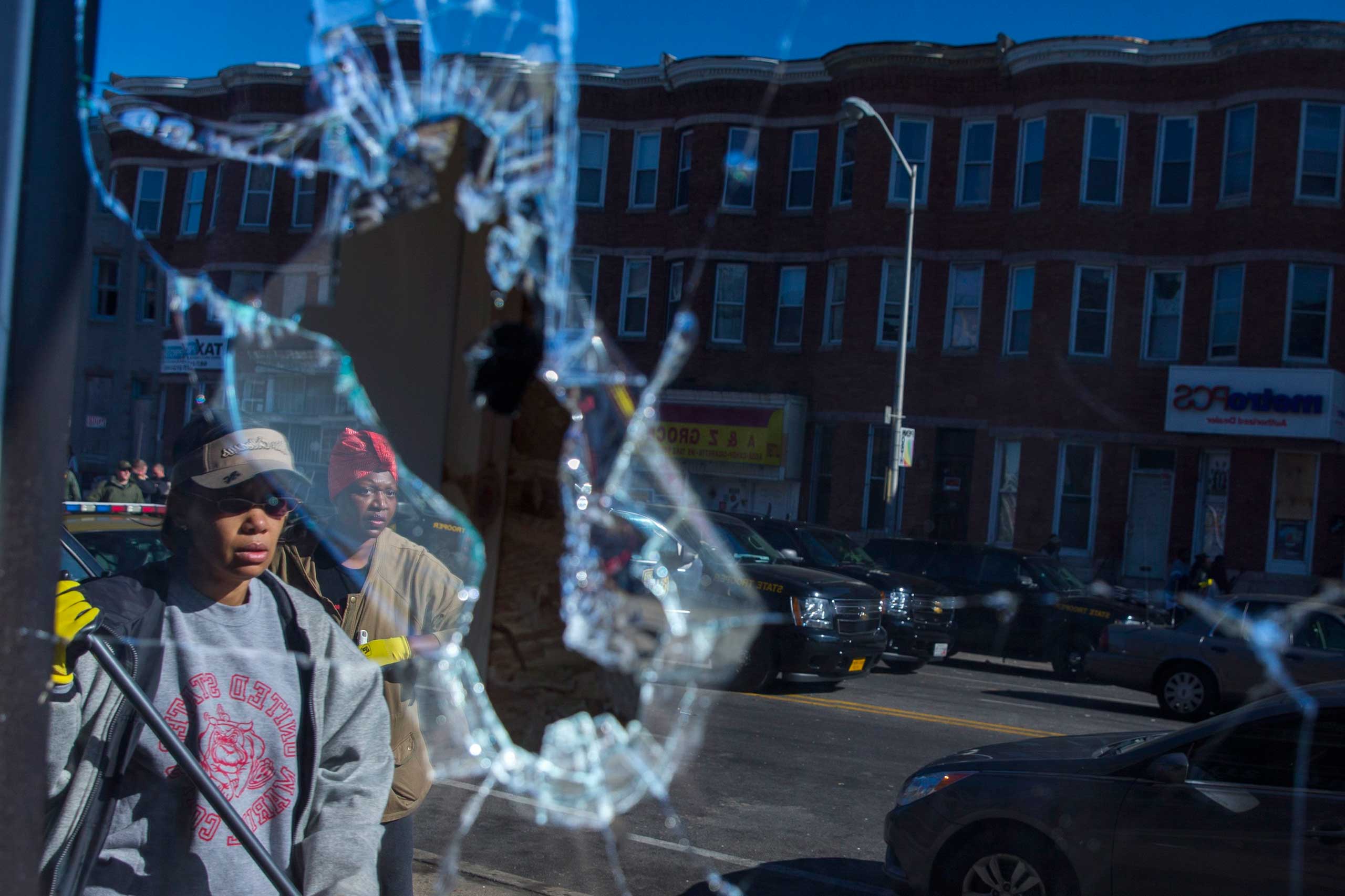 Residents clean up after  a night of riots in Baltimore on April 28, 2015.