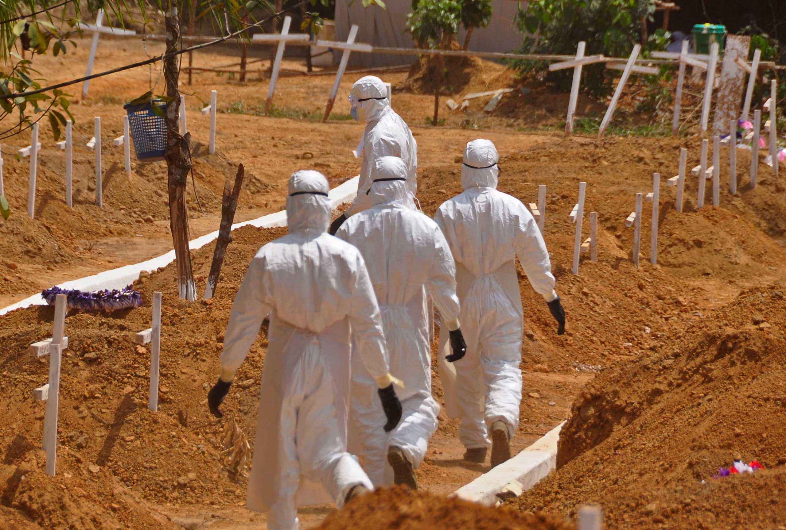 Health workers walk inside a new graveyard for Ebola victims, on the outskirts of Monrovia, Liberia on March 11, 2015. (Abbas Dulleh—AP)