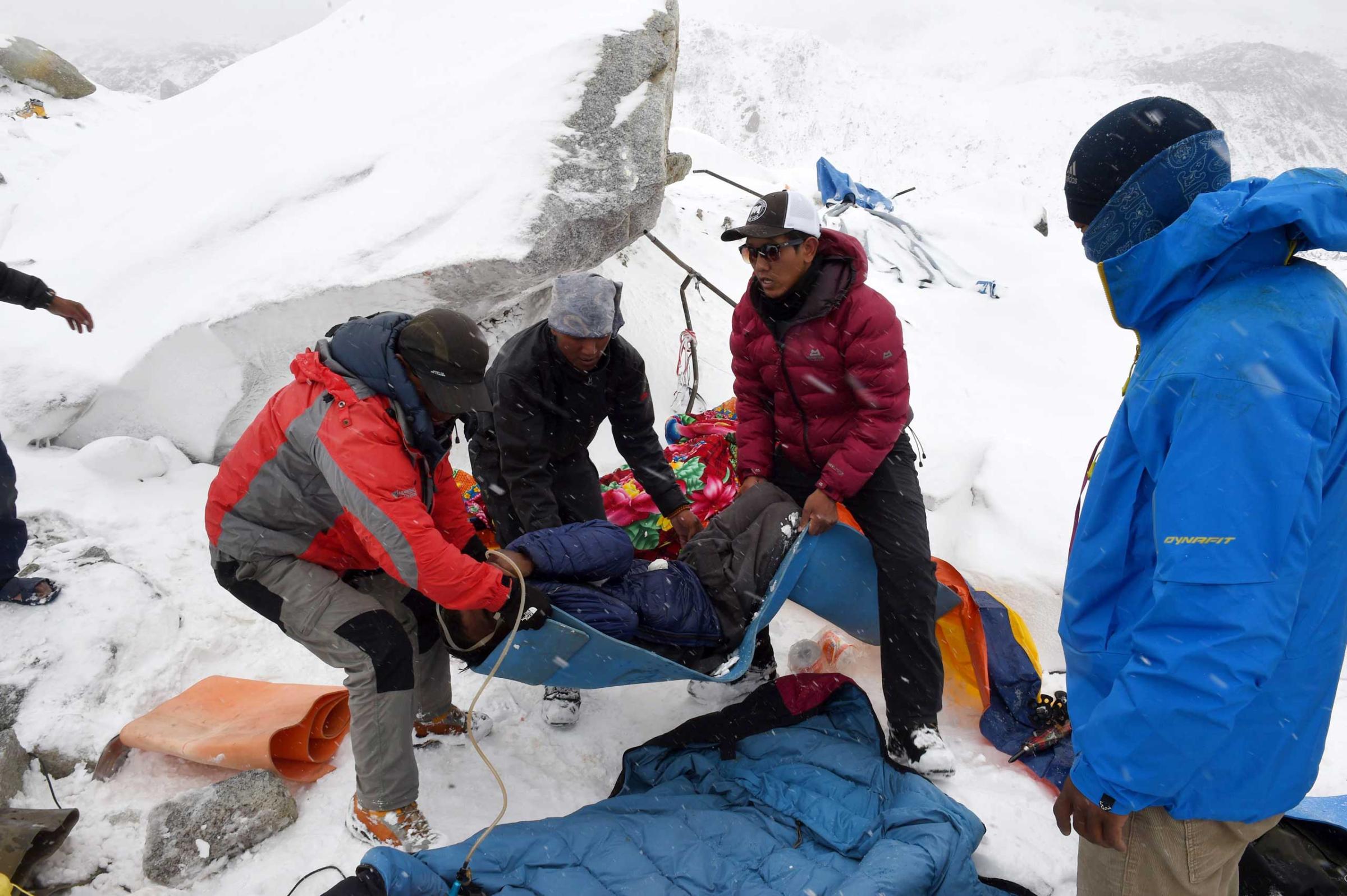 Rescuers help a porter onto a makeshift stretcher after he was injured by the avalanche on Mount Everest, triggered by an earthquake outside Kathmandu, Nepal.
