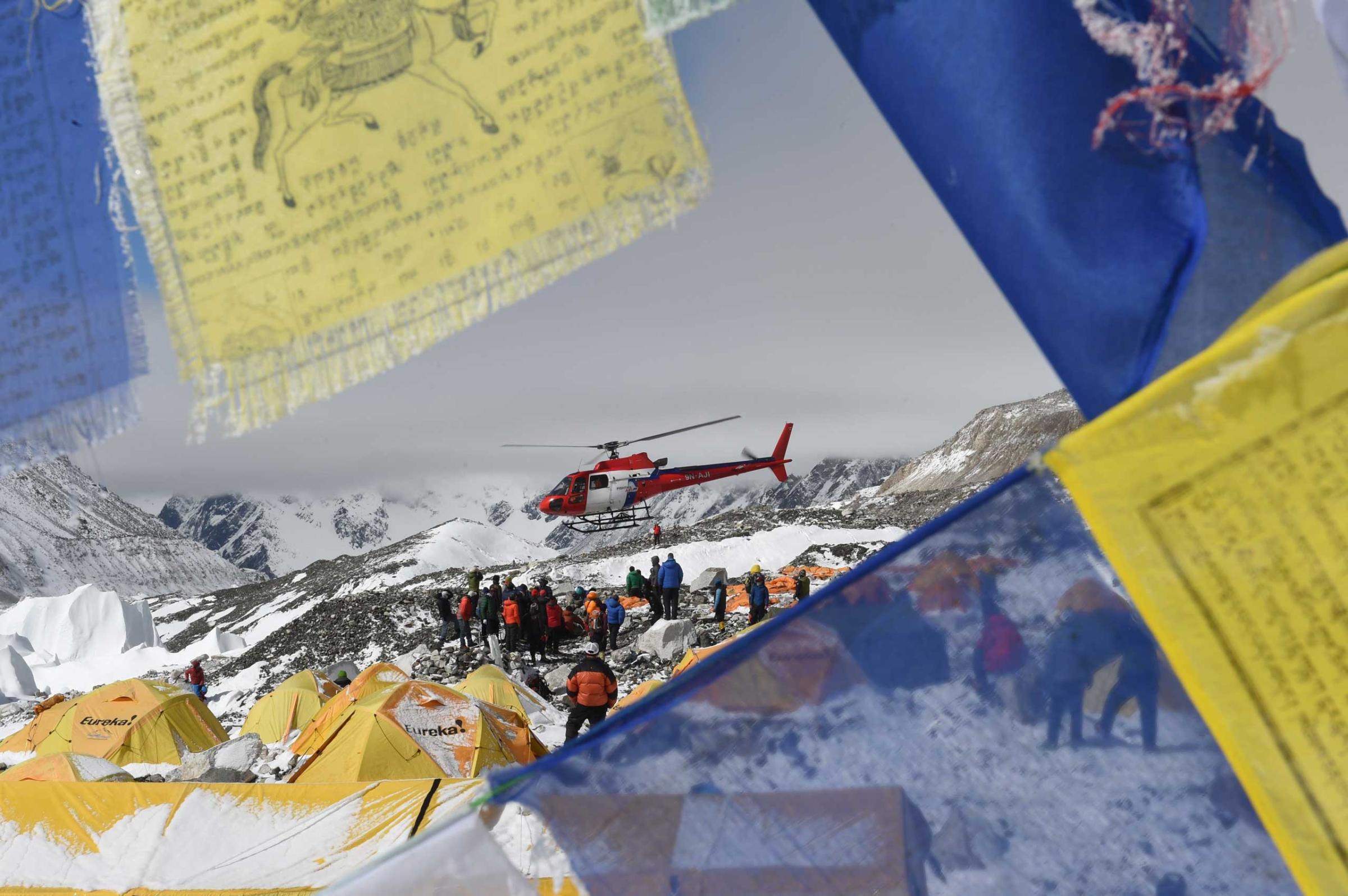 Prayer flags frame a rescue helicopter as it ferries the injured from Everest Base Camp on April 26, 2015, one day after an avalanche triggered by an earthquake outside Kathmandu, Nepal.